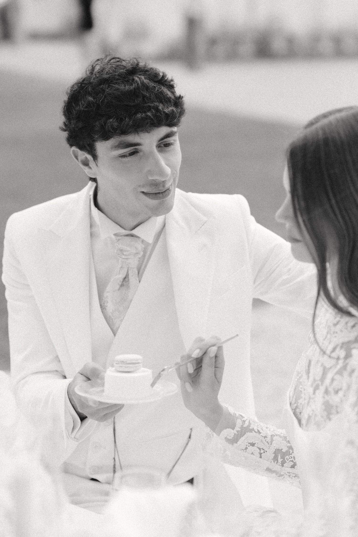 A couple in white attire share an intimate moment during what appears to be a wedding celebration. Villa Mosconi Bertani
