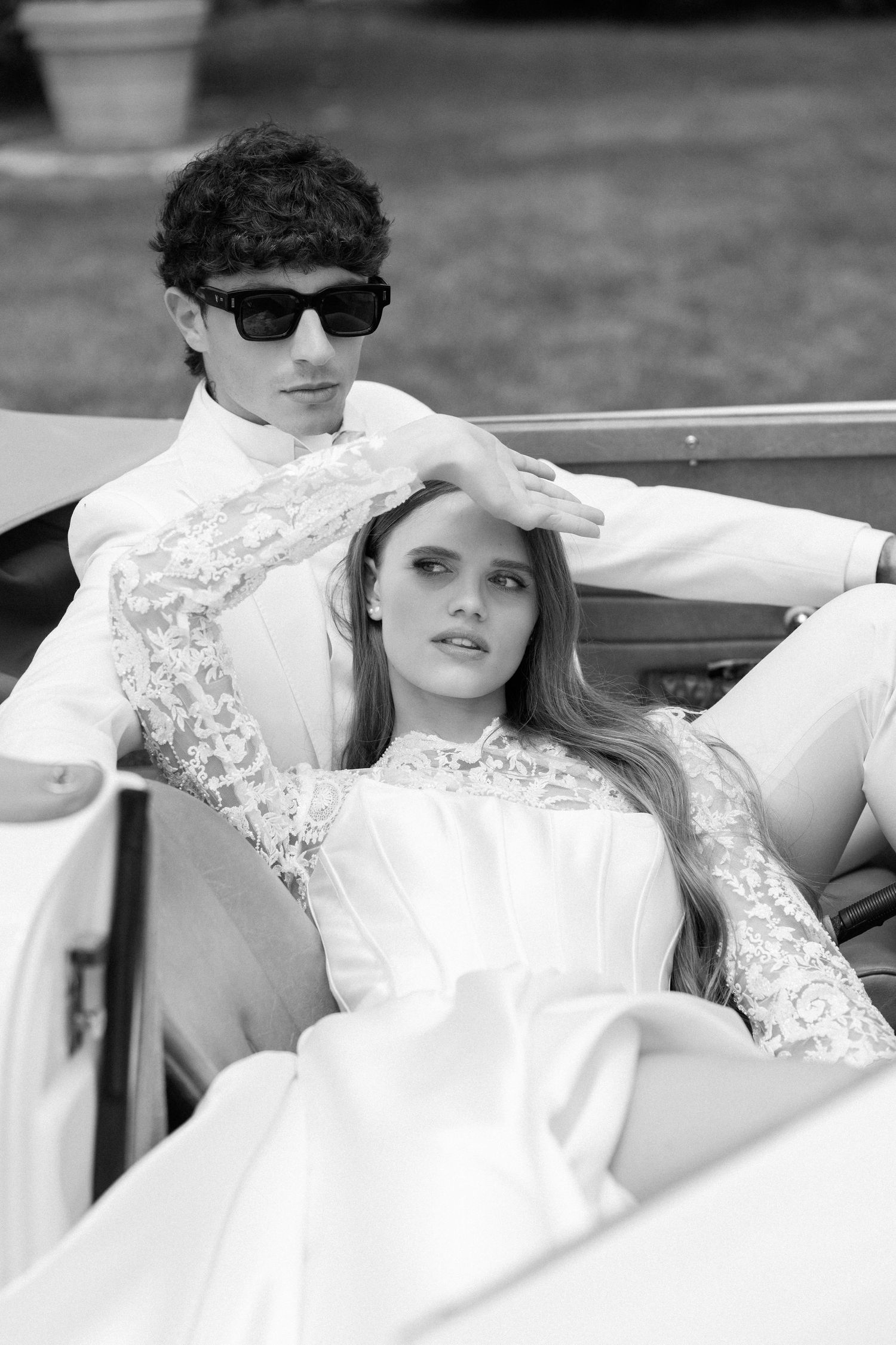 A black and white wedding photo series showing a couple posing together with the bride in an elegant lace gown. Villa Mosconi Bertani