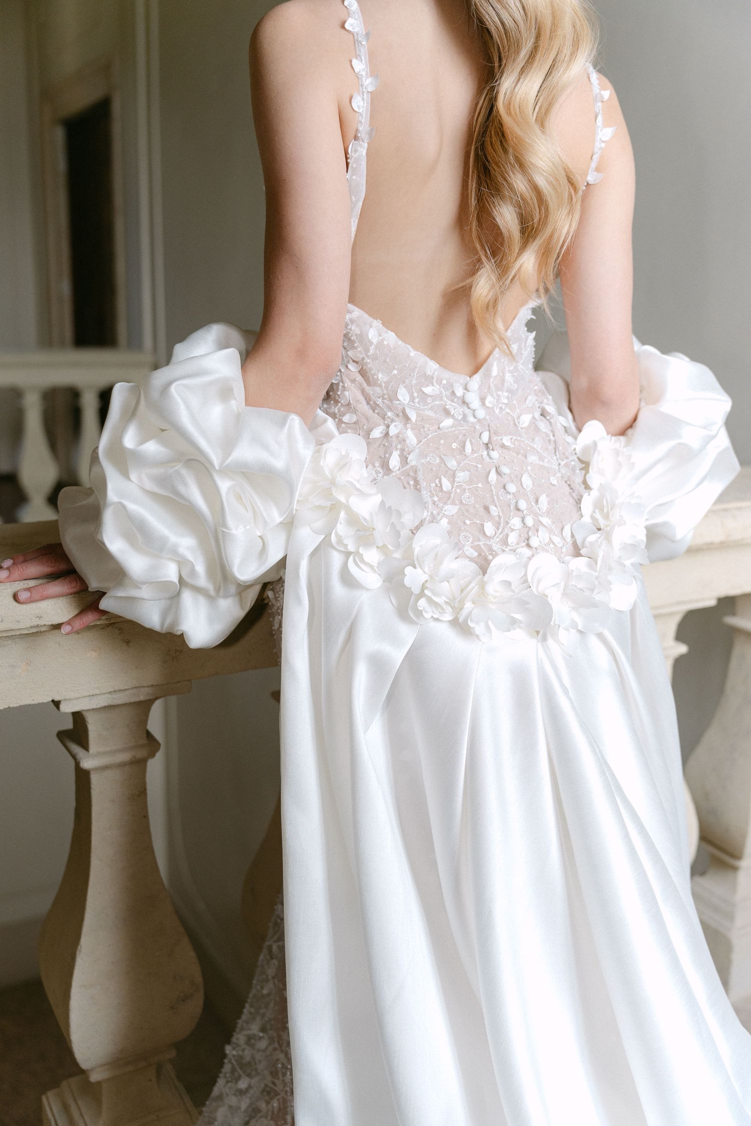 Close-up detail of white wedding gown showing intricate lace back and gathered fabric details. Wedding Verona