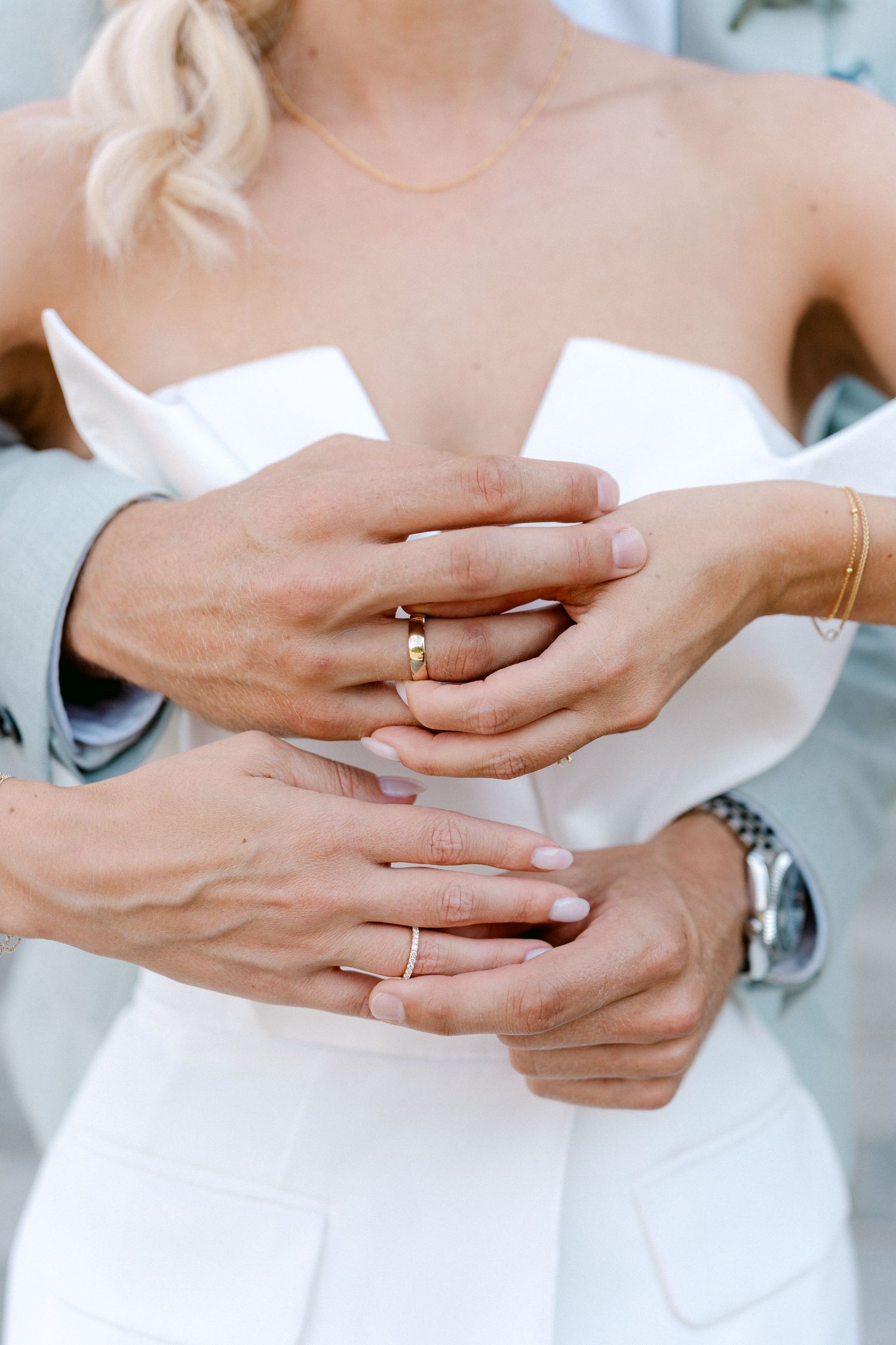 Close-up shots of hands with delicate gold rings against a white dress showing multiple angles and details. Schloss Solitude