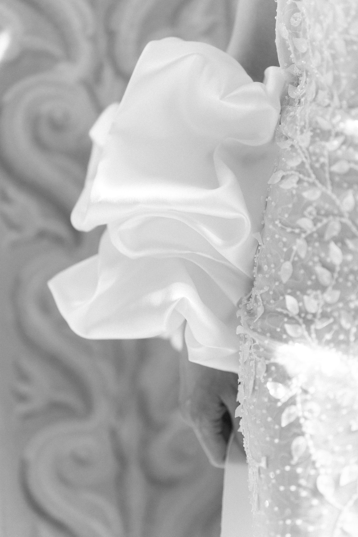 A series of white orchid flowers shown in a repeating pattern against a gray blurred background. Wedding Verona