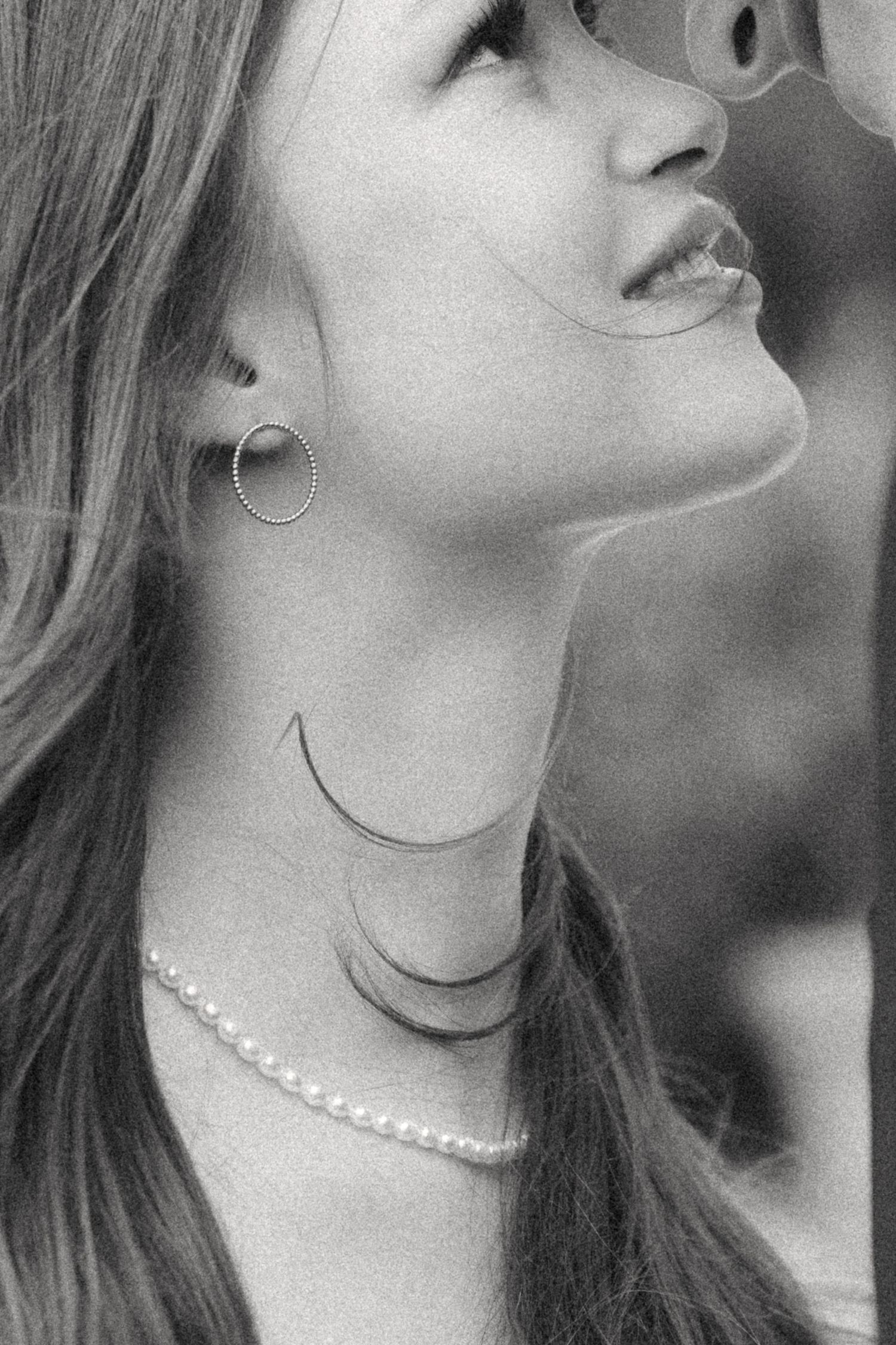 Black and white portrait series showing a woman wearing a pearl necklace in various poses with upward gazes.