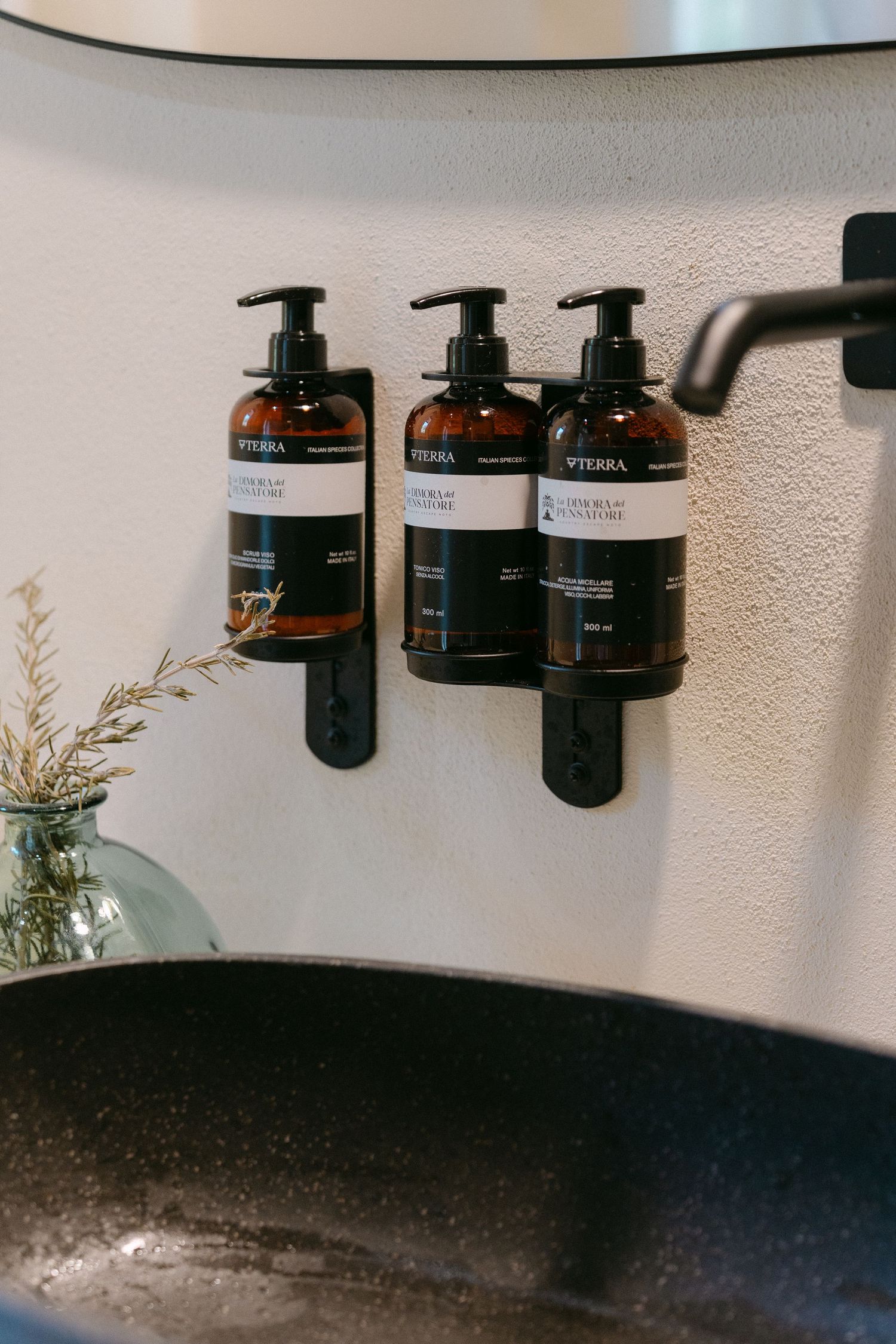 Minimalist display of wellness product bottles mounted on a white wall.