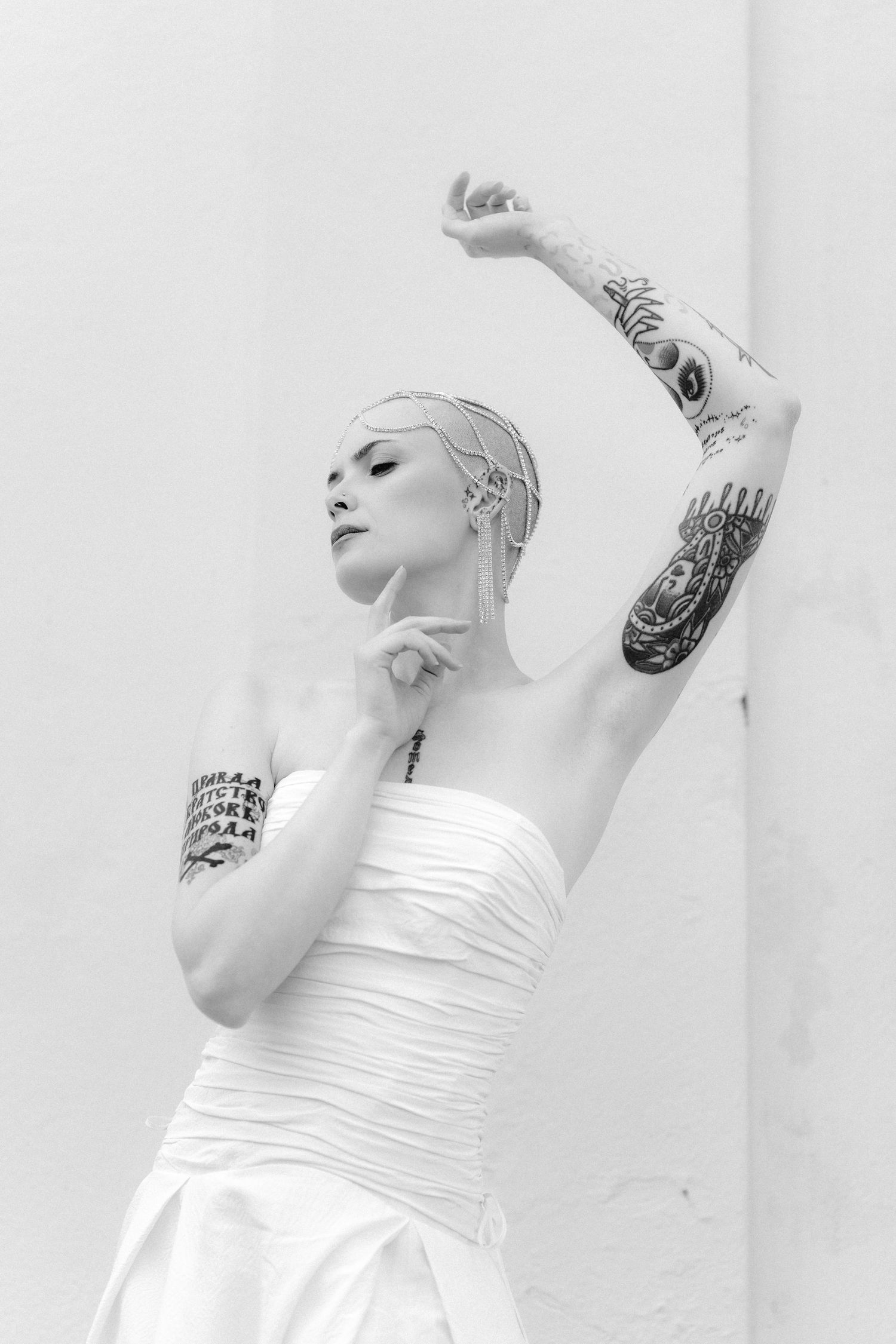 Artistic black and white photo series showing a dancer in white dress performing graceful movements against a light wall.