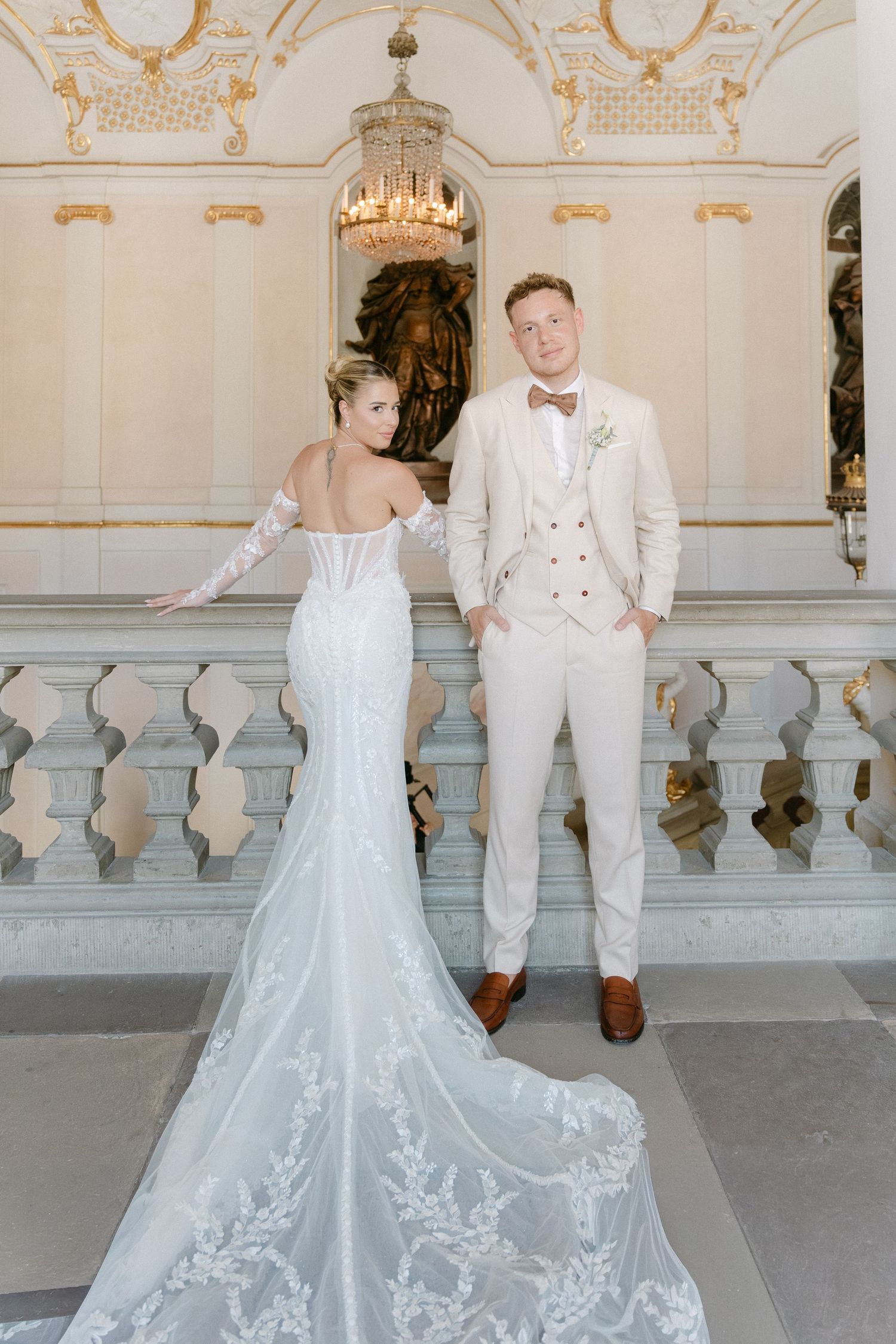 A bride and groom share a joyful first look moment on a grand marble balcony with ornate architectural details. Schloss Ludwigsburg