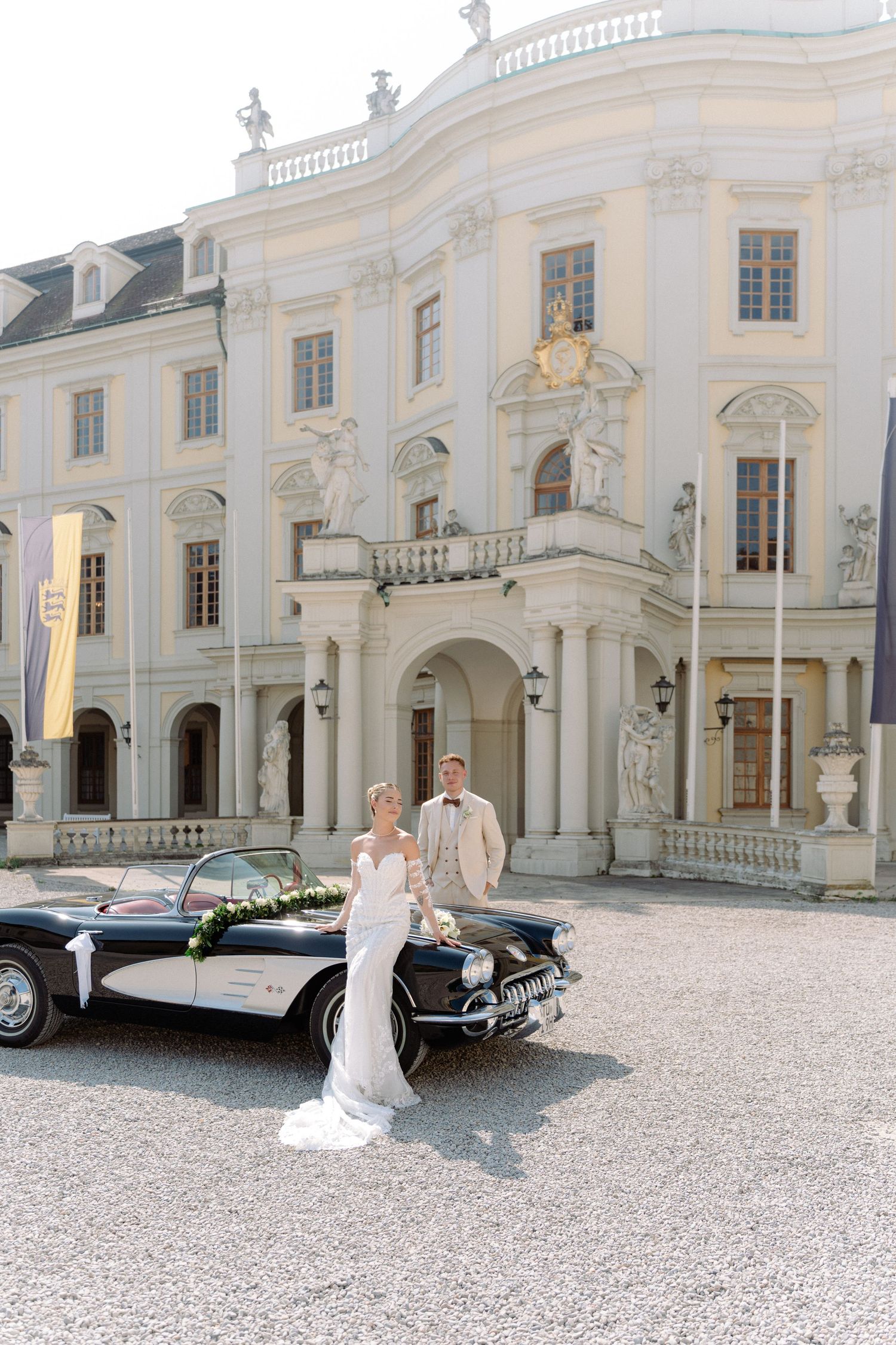 Elegant wedding photo series at a grand white baroque palace with a vintage car and ornate architectural details. Schloss Ludwigsburg