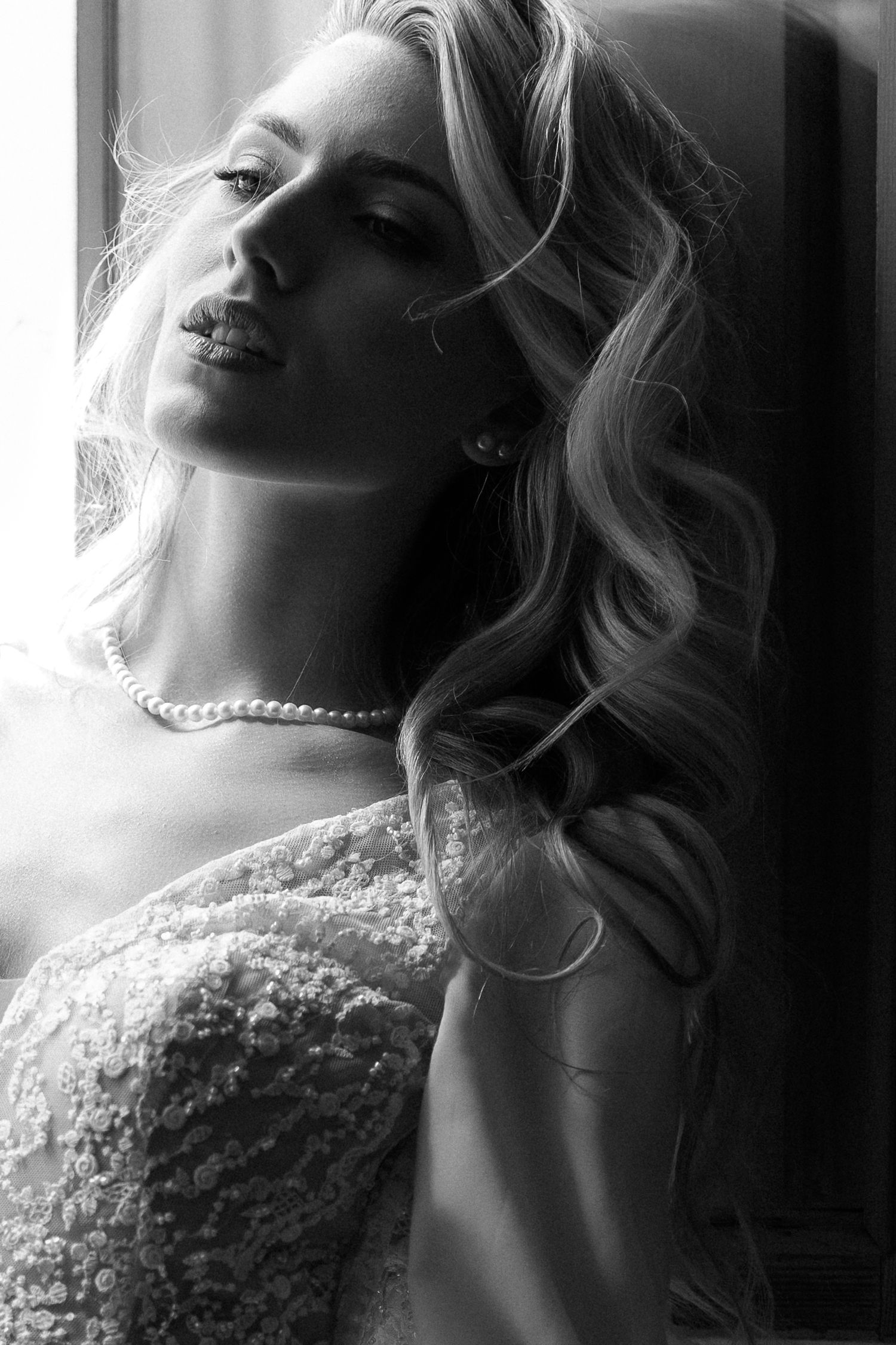 A series of black and white glamour portraits showing a woman wearing pearls and a lace dress in dramatic lighting. Wedding Verona