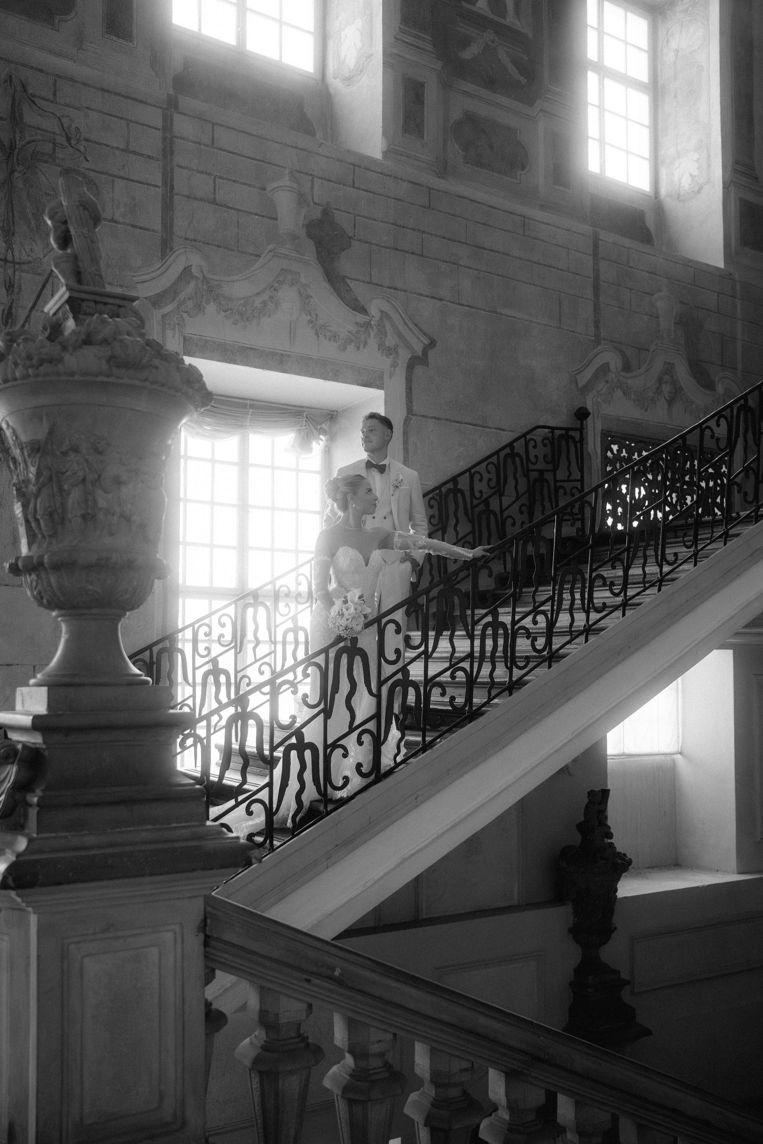 Elegant black wrought iron staircase railing with ornate details in a historic building with sunlit windows. Schloss Ludwigsburg