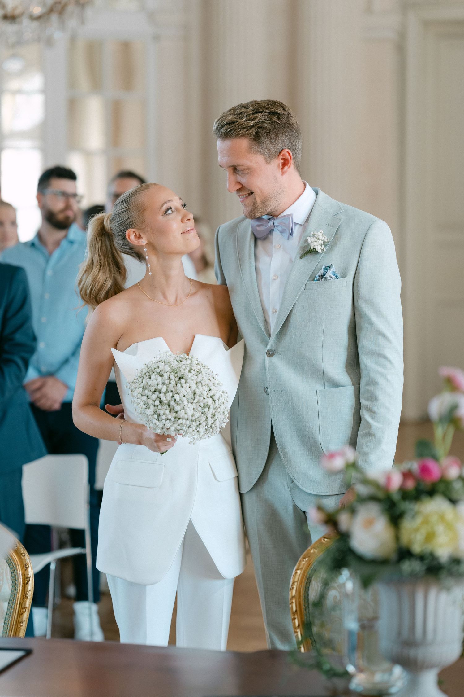 Bride and groom share intimate moments during their wedding ceremony in a light-filled venue with elegant decor. Schloss Solitude