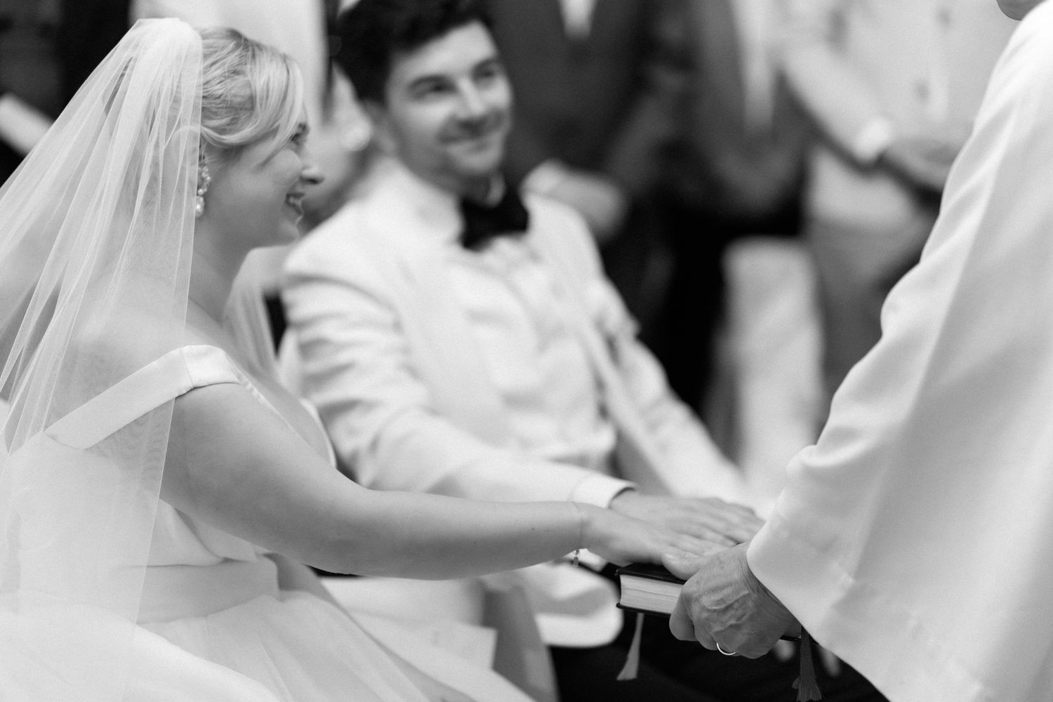 A happy couple shares a romantic dance moment at their wedding reception with guests in the background.