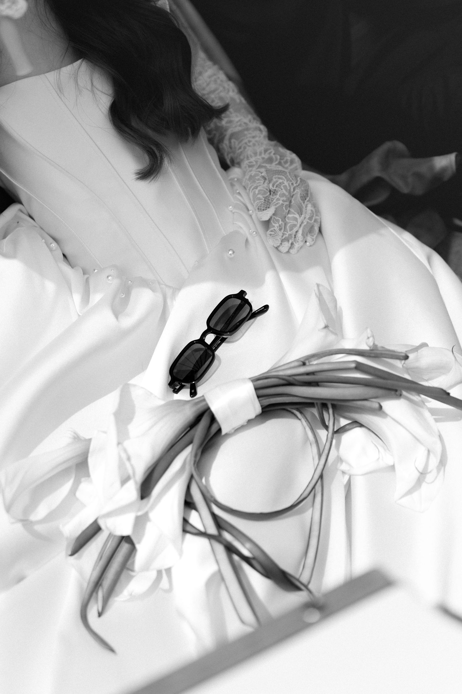 A black and white photo series showing a close-up view of white fabric with lace details and buttons.
