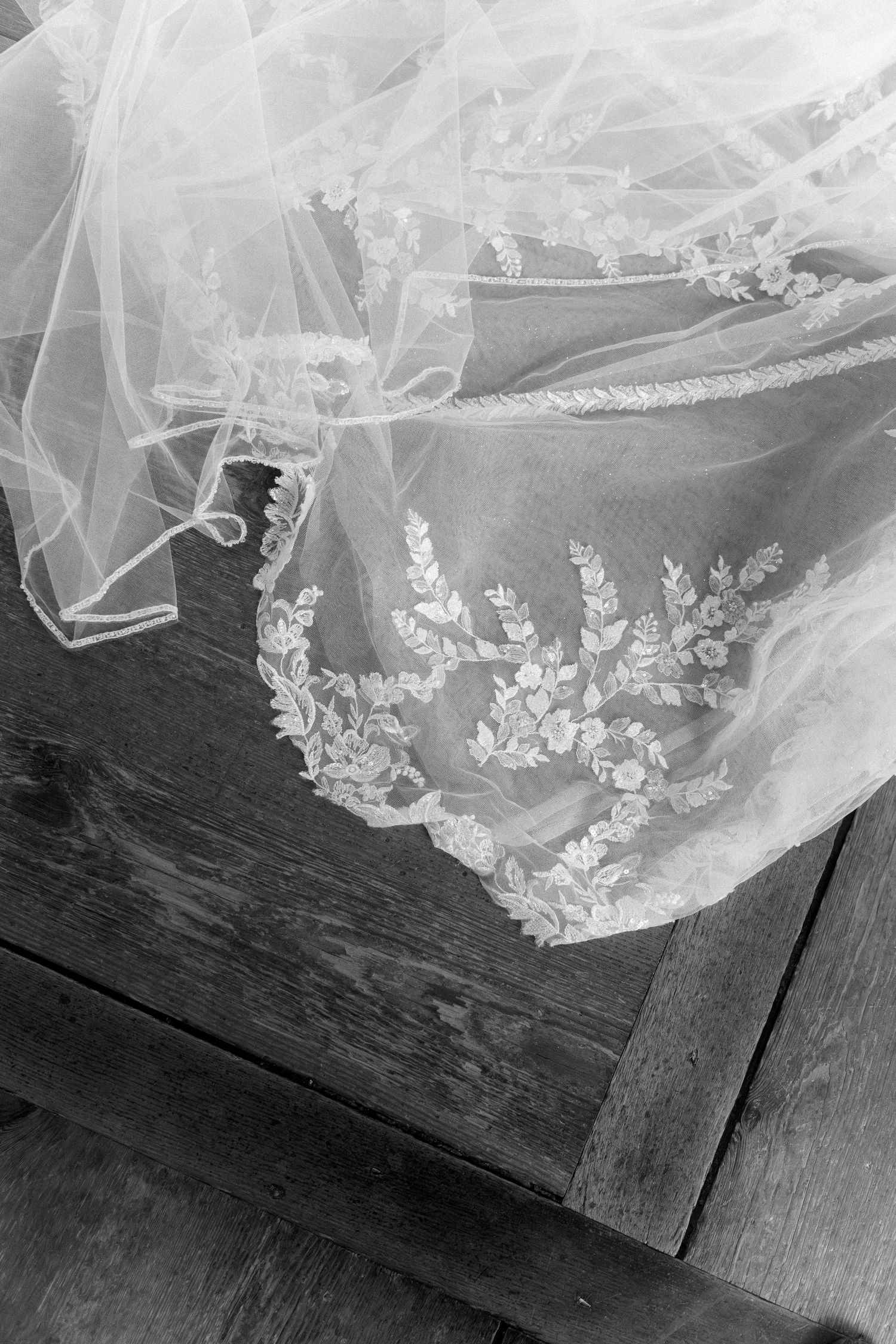 Delicate white lace trim with floral embroidery details cascades over a dark wooden surface. Schloss Ludwigsburg