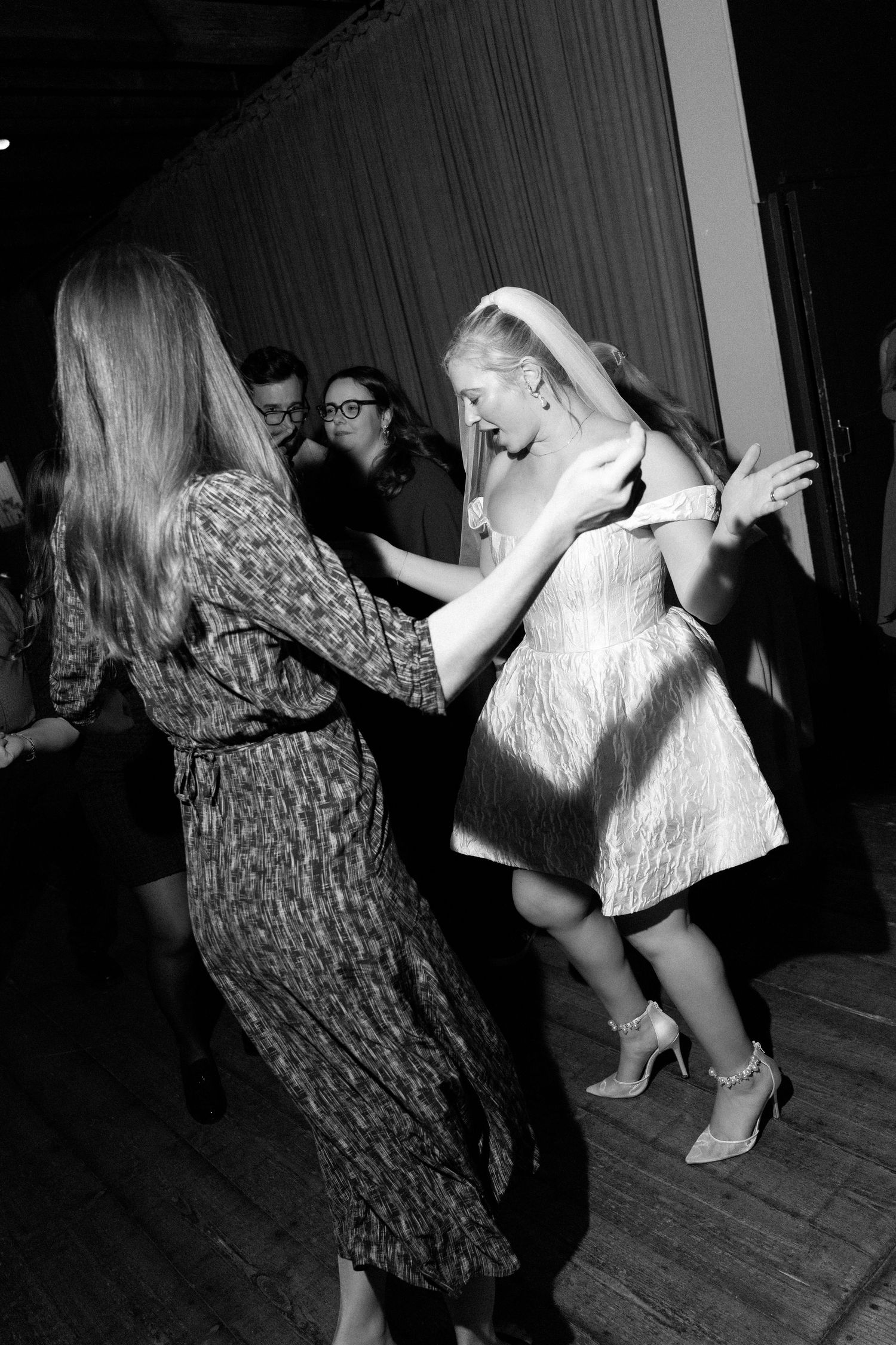 Black and white photo sequence showing people dancing energetically on a wooden floor.