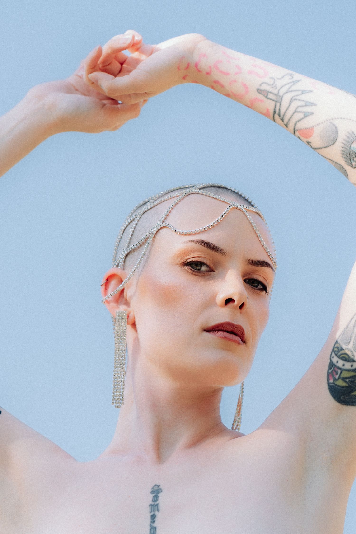 A series of artistic portraits showing someone with dramatic makeup and jewelry against a light blue background.