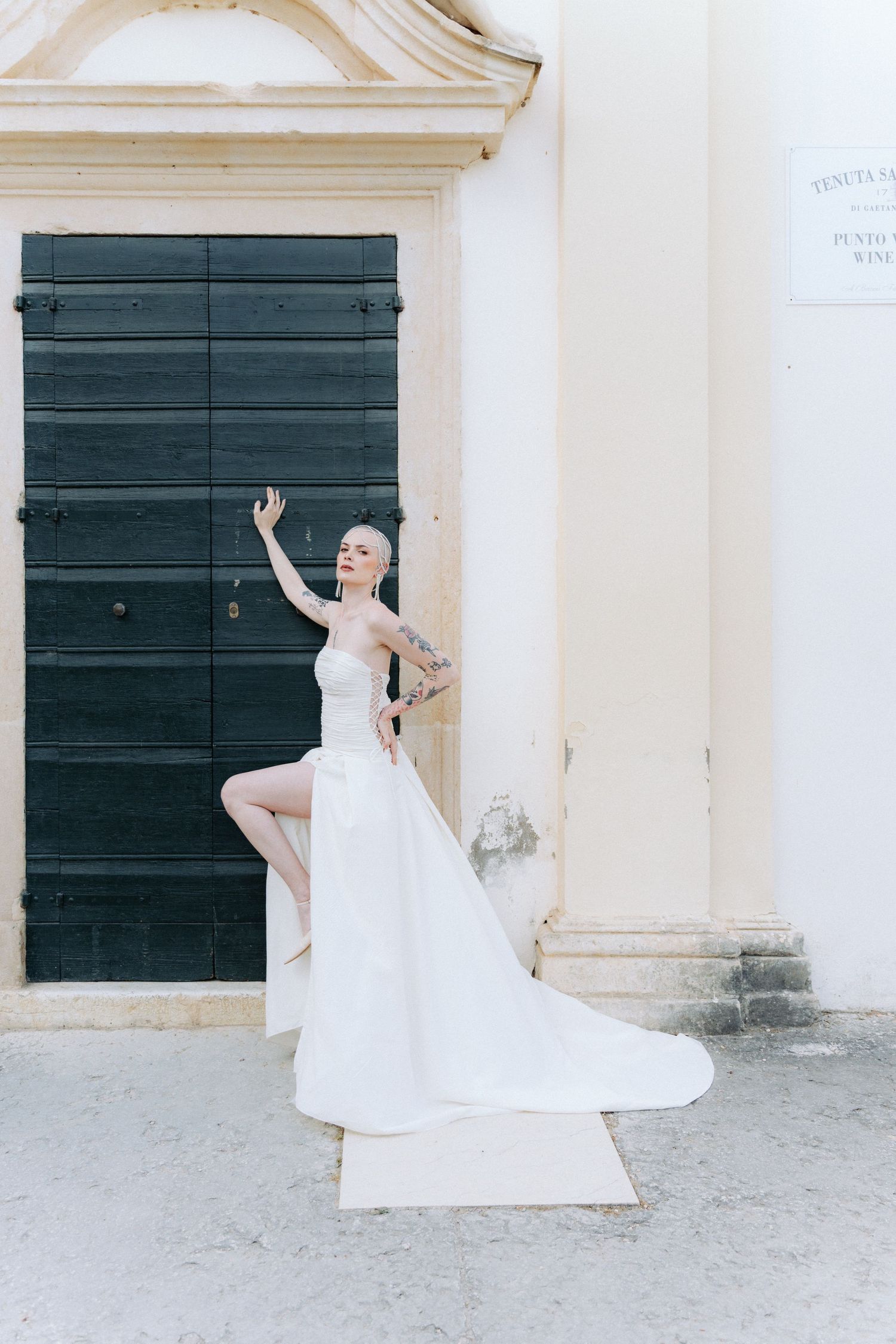 A sequence of artistic bridal poses in front of a white building with dark green doors.
