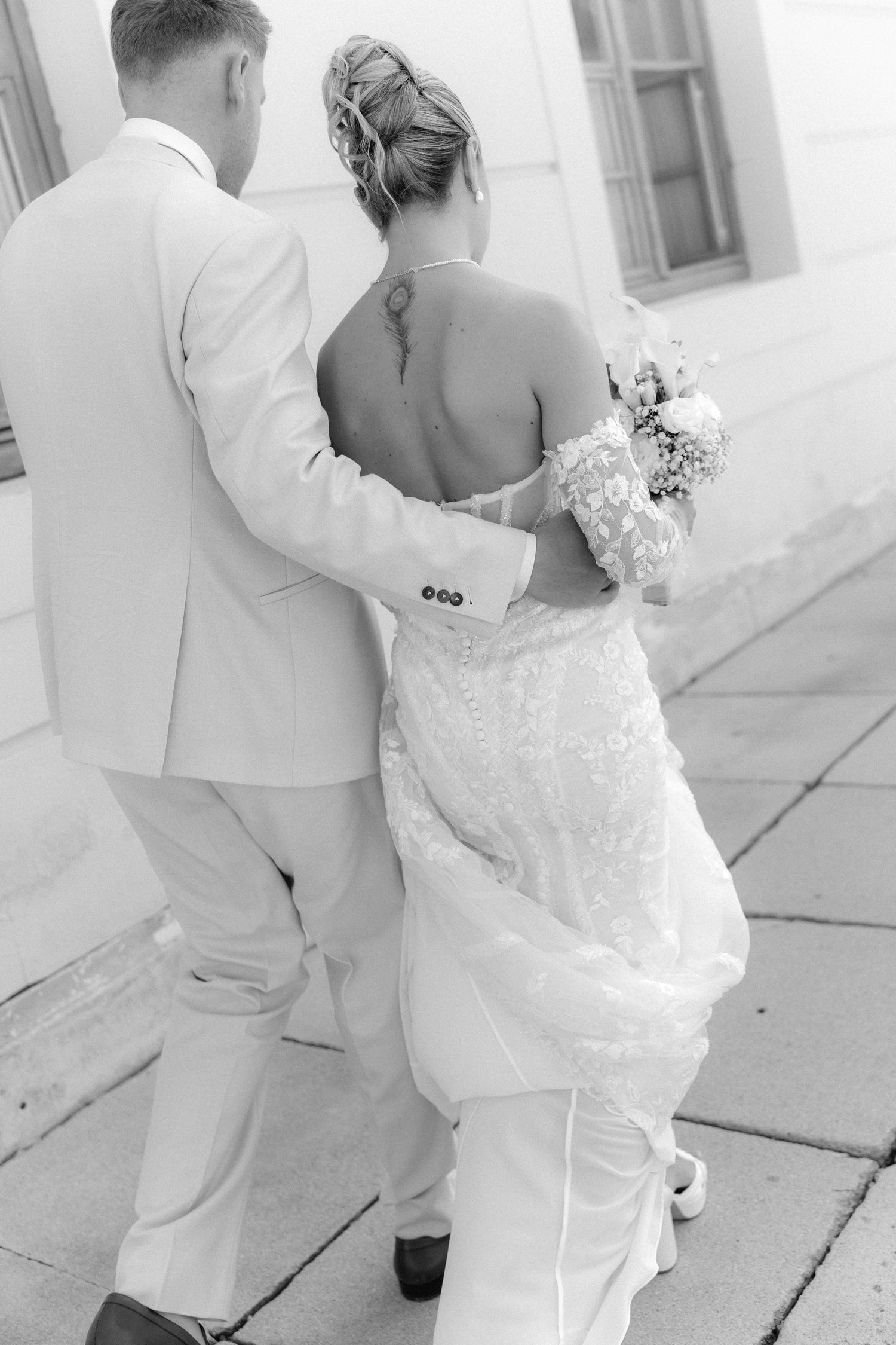 A couple in white attire dancing together on a bright porch, creating a romantic wedding moment. Schloss Ludwigsburg