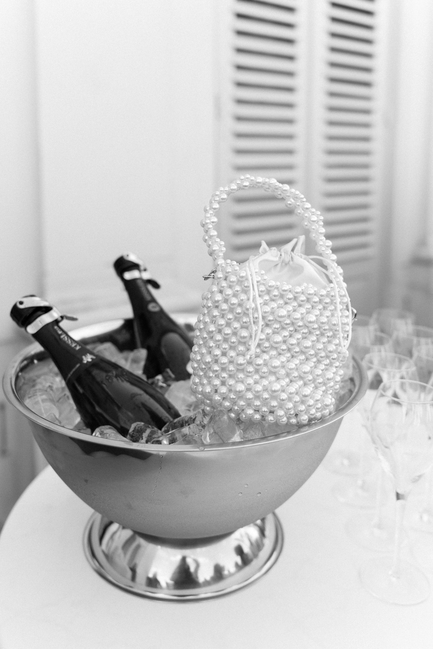 Champagne bottles chilling in silver ice bowls with pearl-like decorative elements at an elegant event setup. Schloss Solitude