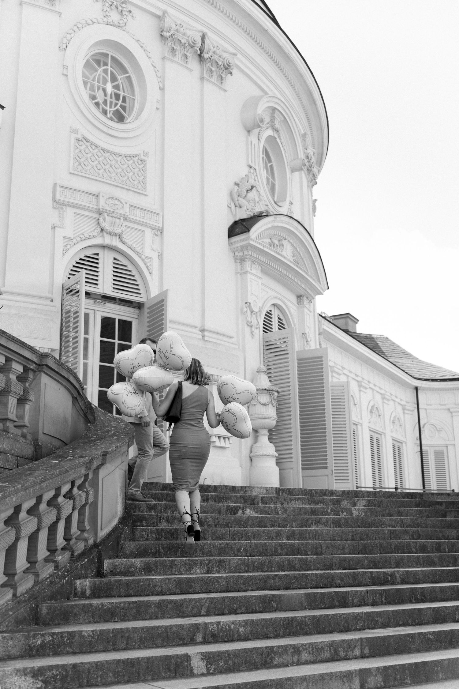 A sequence of four photos showing a person rolling down ornate stone steps in front of a classical white building. Schloss Solitude