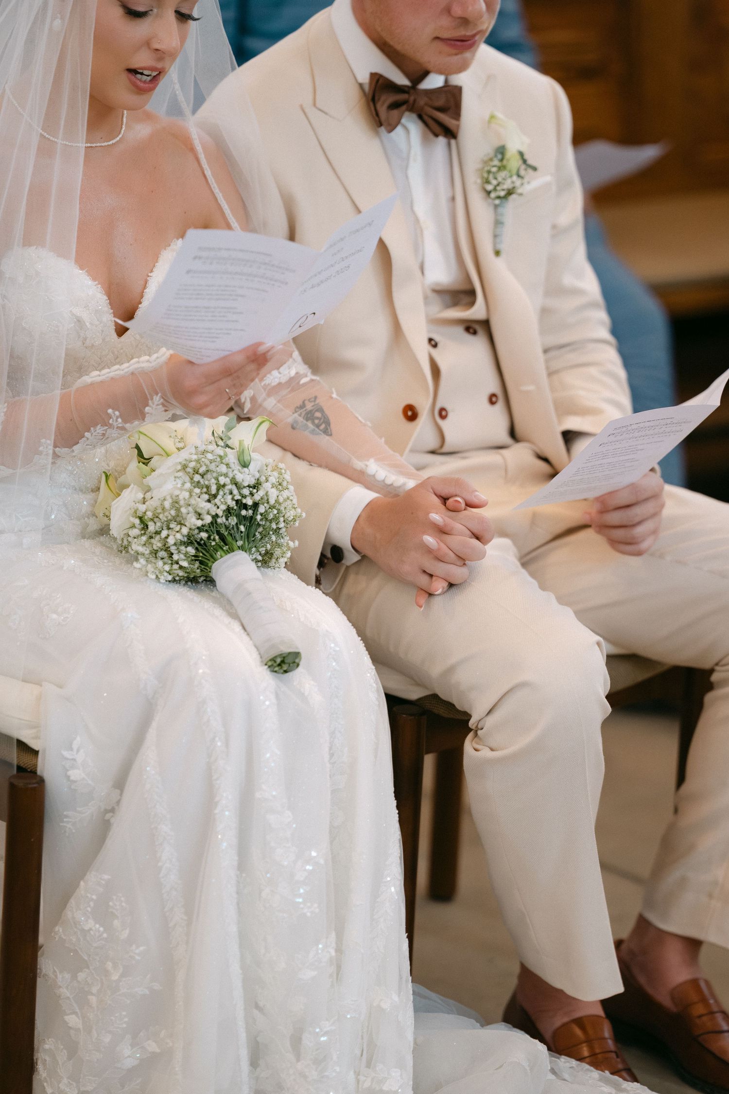 Bride and groom reading vows during intimate wedding ceremony with white and cream color palette.