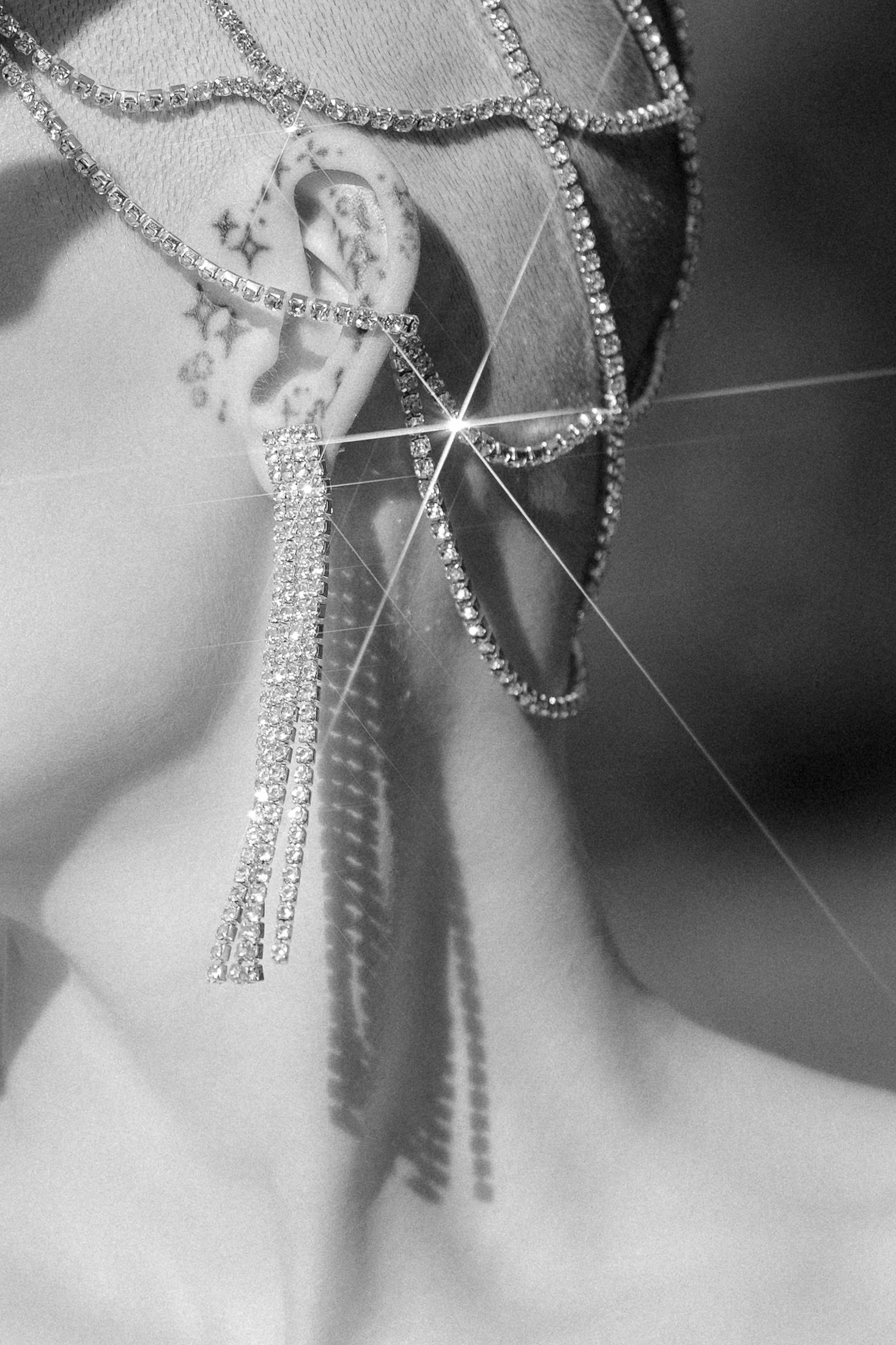 Sparkling diamond necklace and earrings set photographed in elegant black and white with dramatic lighting effects.
