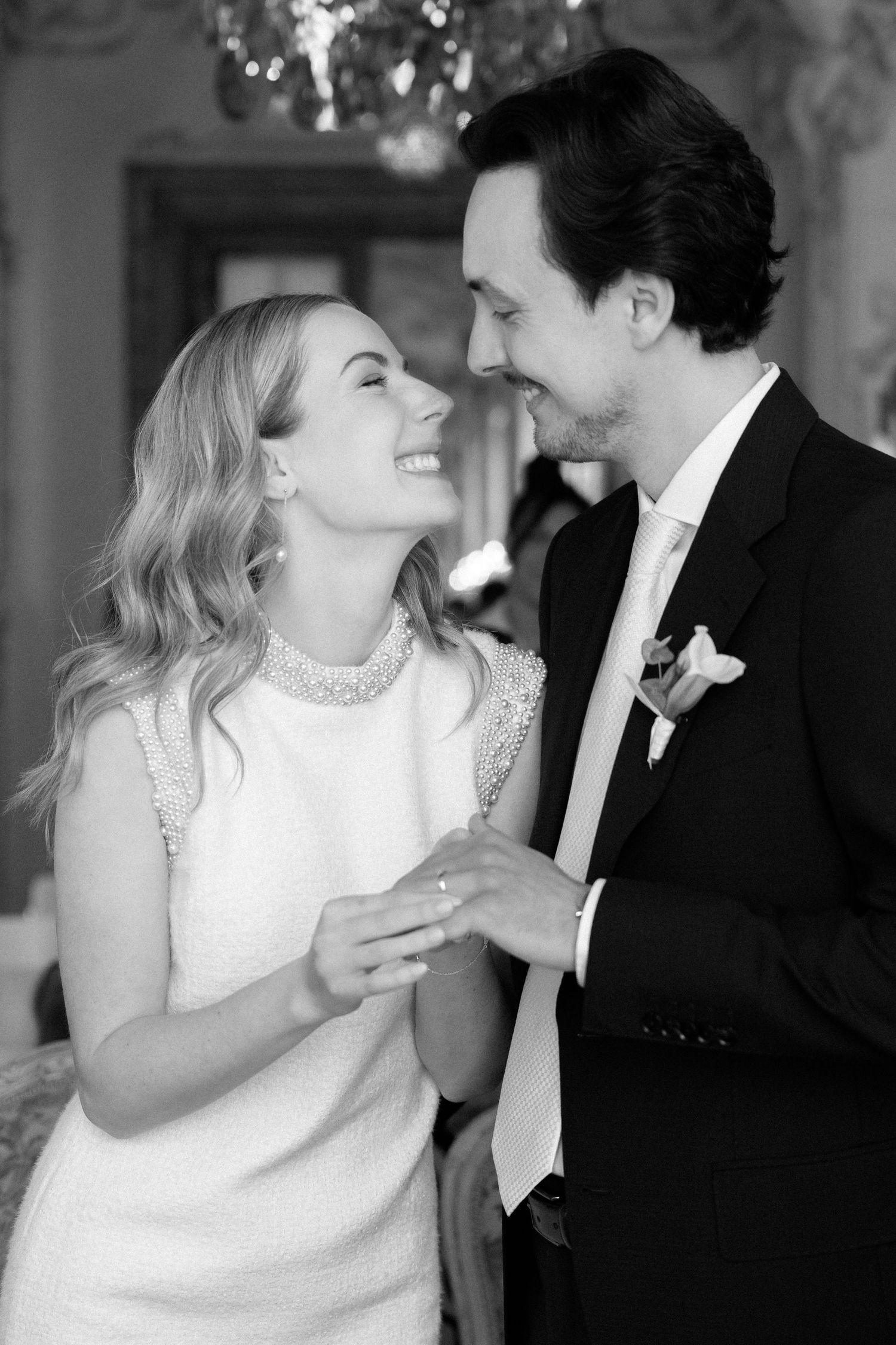 Black and white photo of a smiling bride and groom sharing a tender moment during their wedding reception.