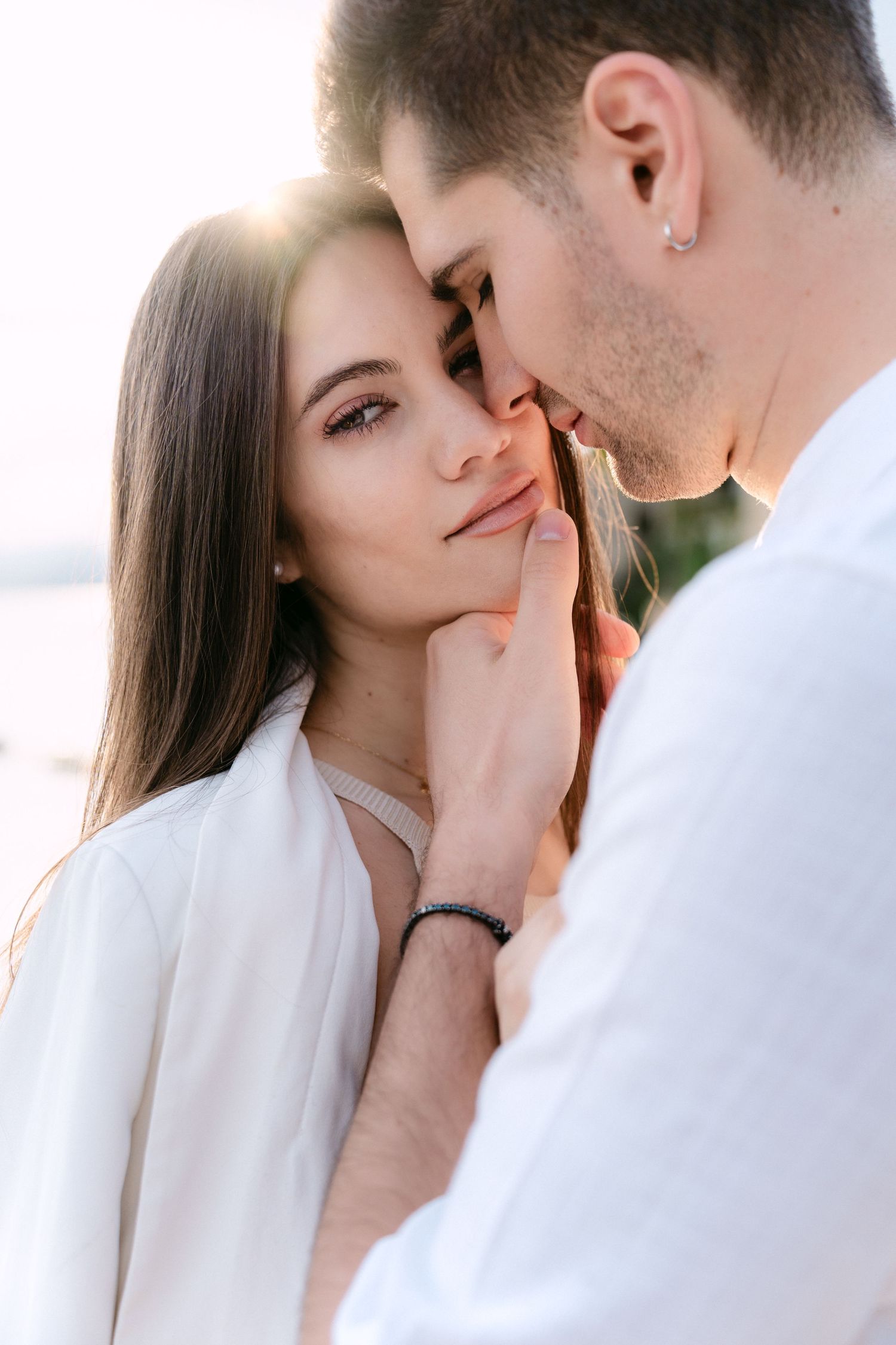 A romantic couple shares an intimate moment in soft lighting, captured in a series of tender close-up photographs.