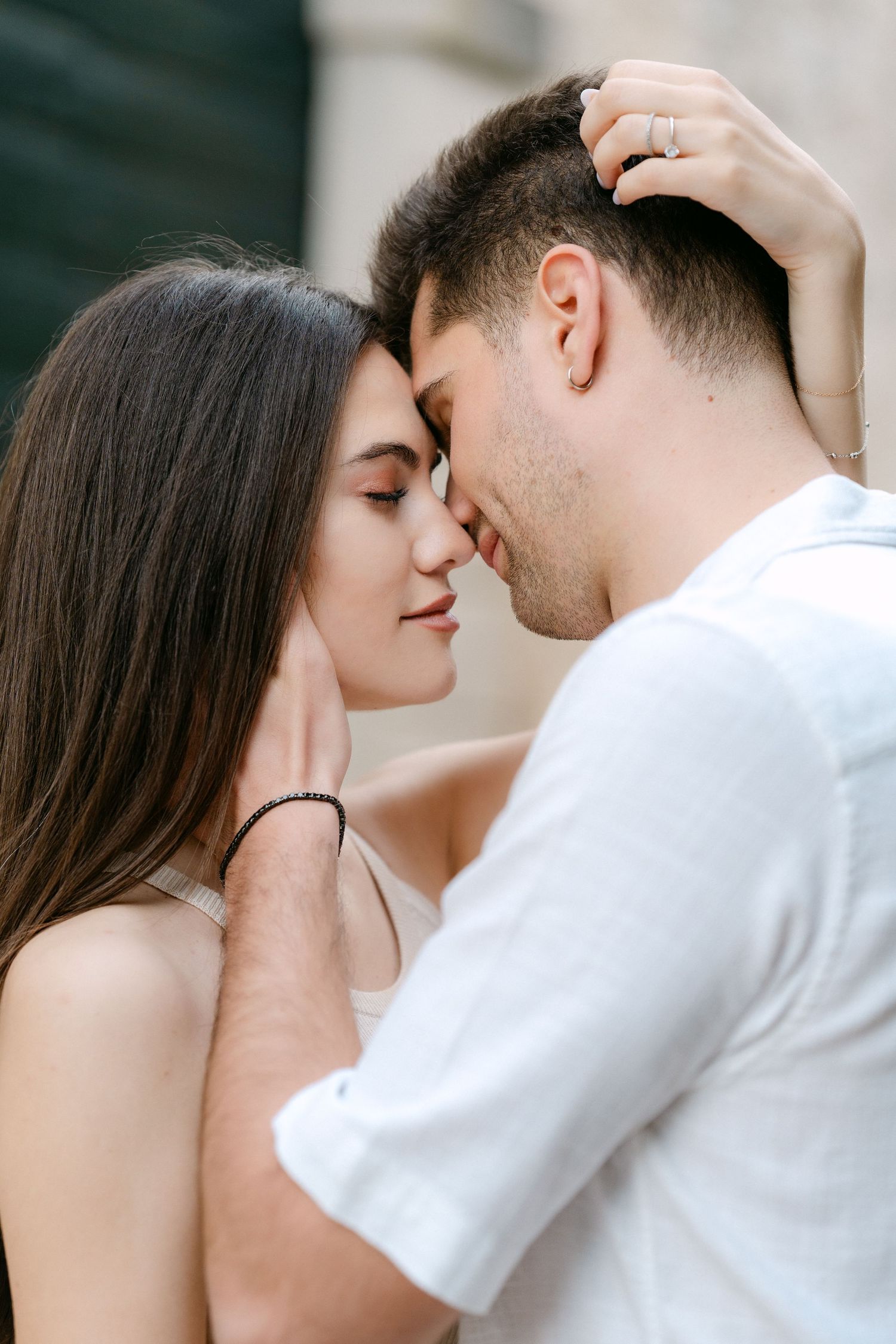 Intimate close-up portraits of a couple in white sharing tender romantic moments together.