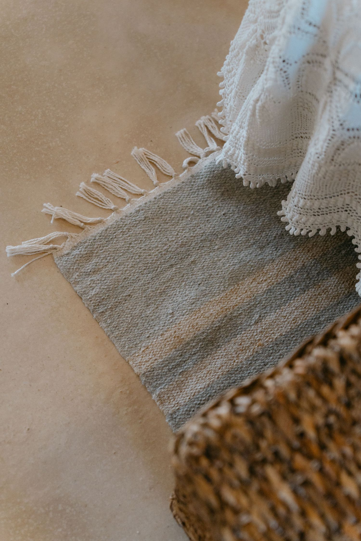Close-up detail of white lace trim against a textured beige background.