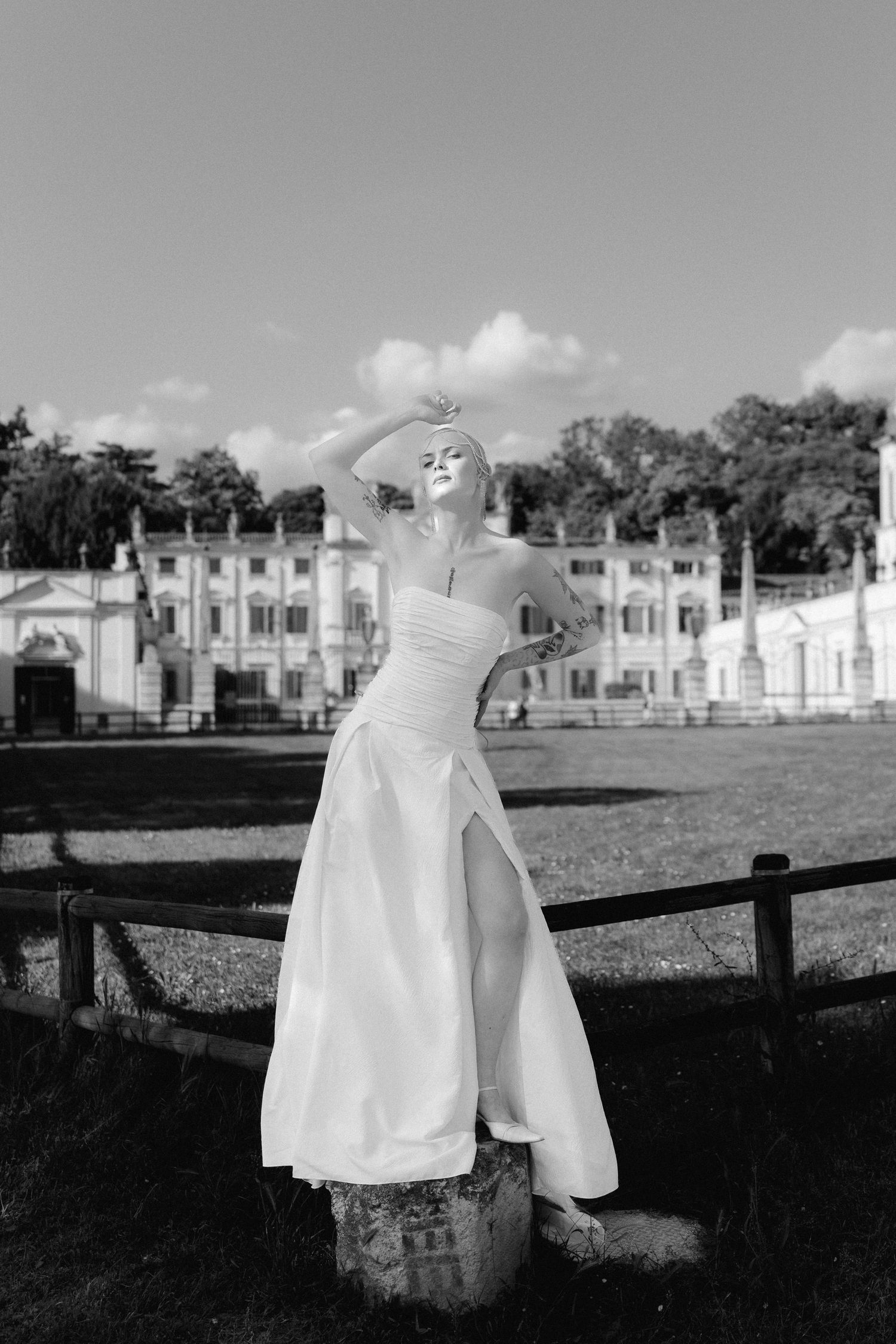 A series of white dresses hanging on a clothesline in front of historic buildings on a sunny day.