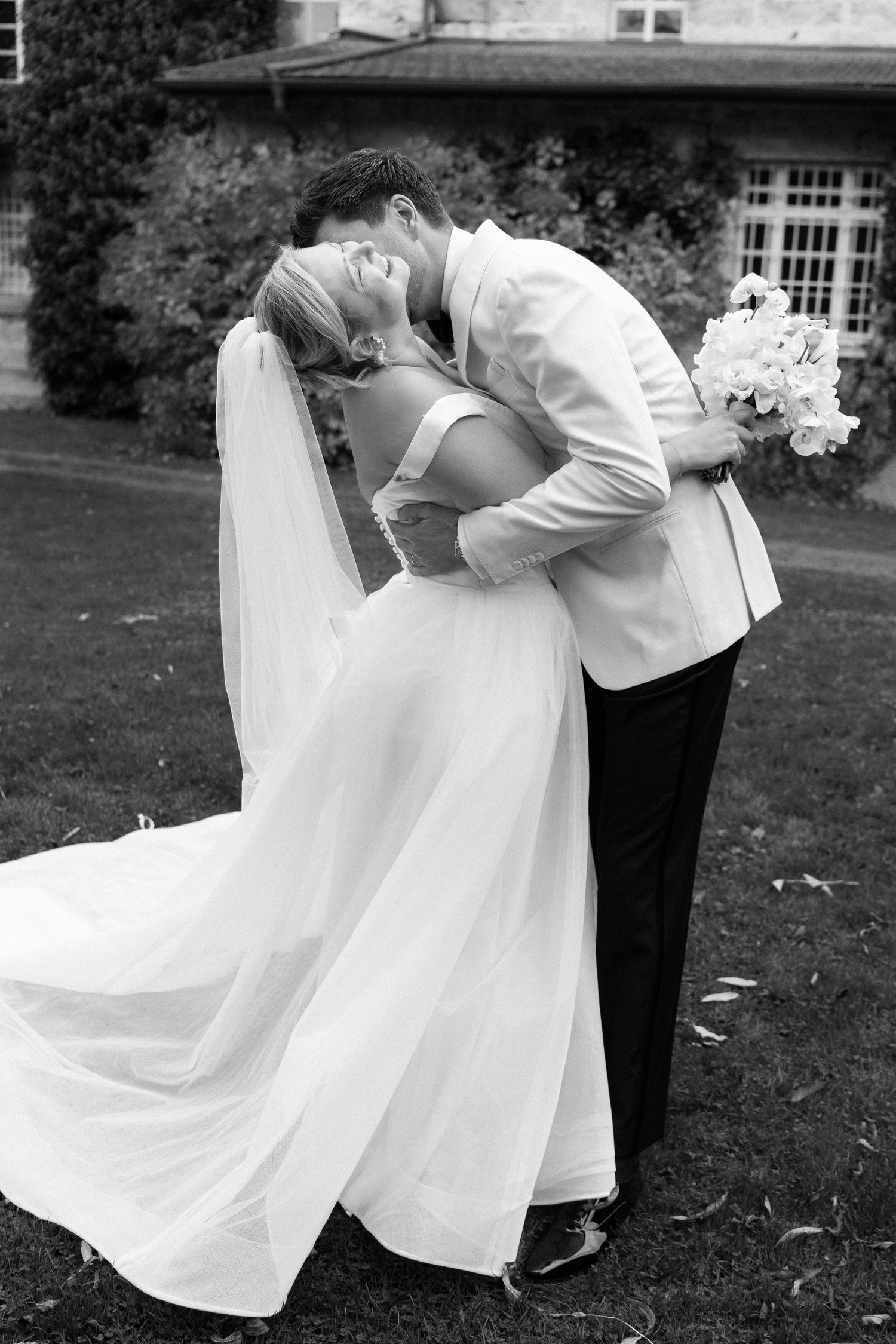A romantic black and white sequence shows a couple dancing gracefully on a lawn, with the bride's white dress flowing elegantly.