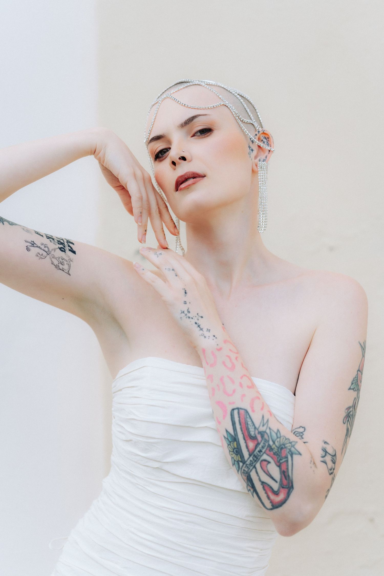 A series of artistic boudoir portraits featuring delicate poses against a light background with visible tattoo artwork.