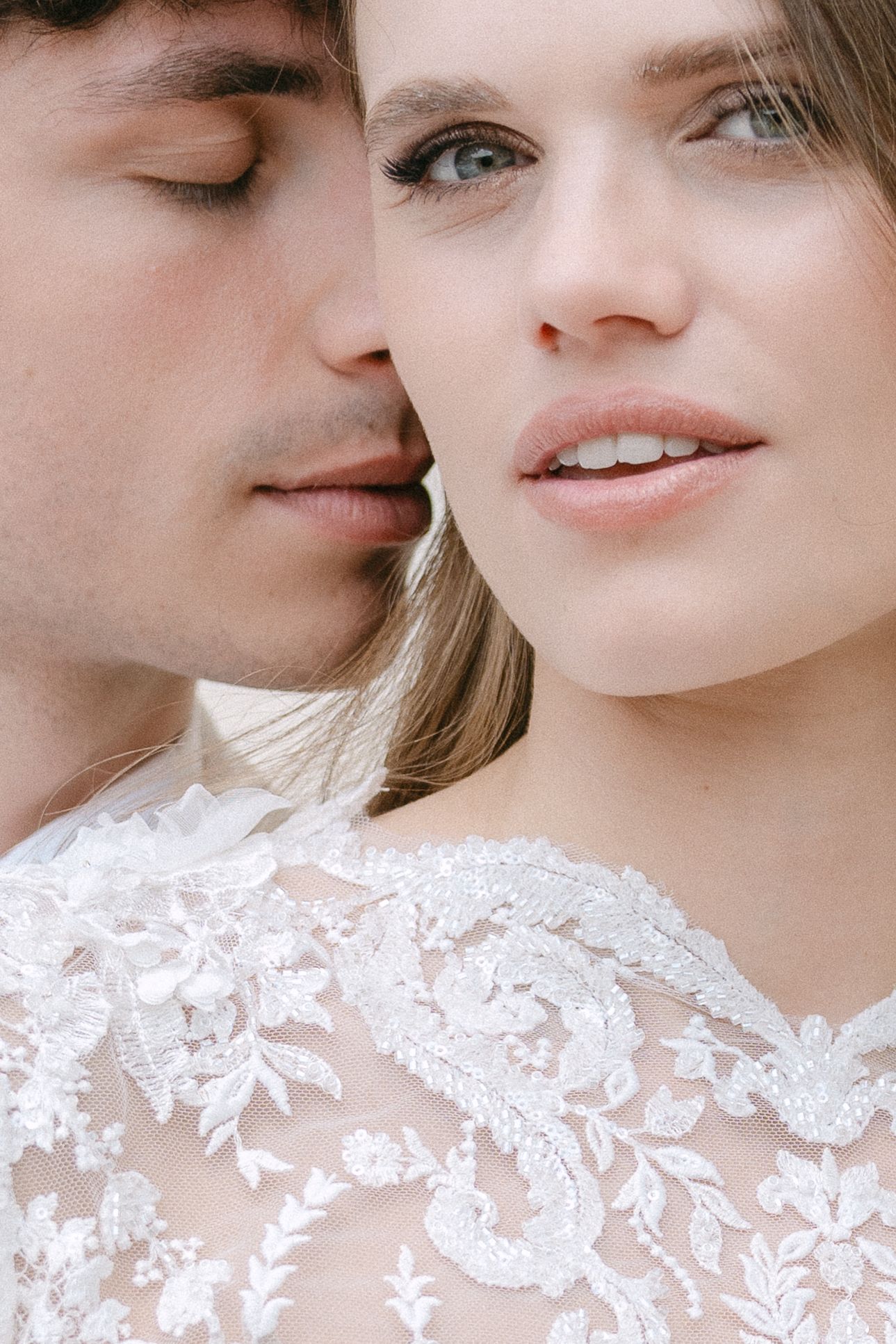 Close up view of a romantic couple in white lace sharing an intimate moment. Villa Mosconi Bertani