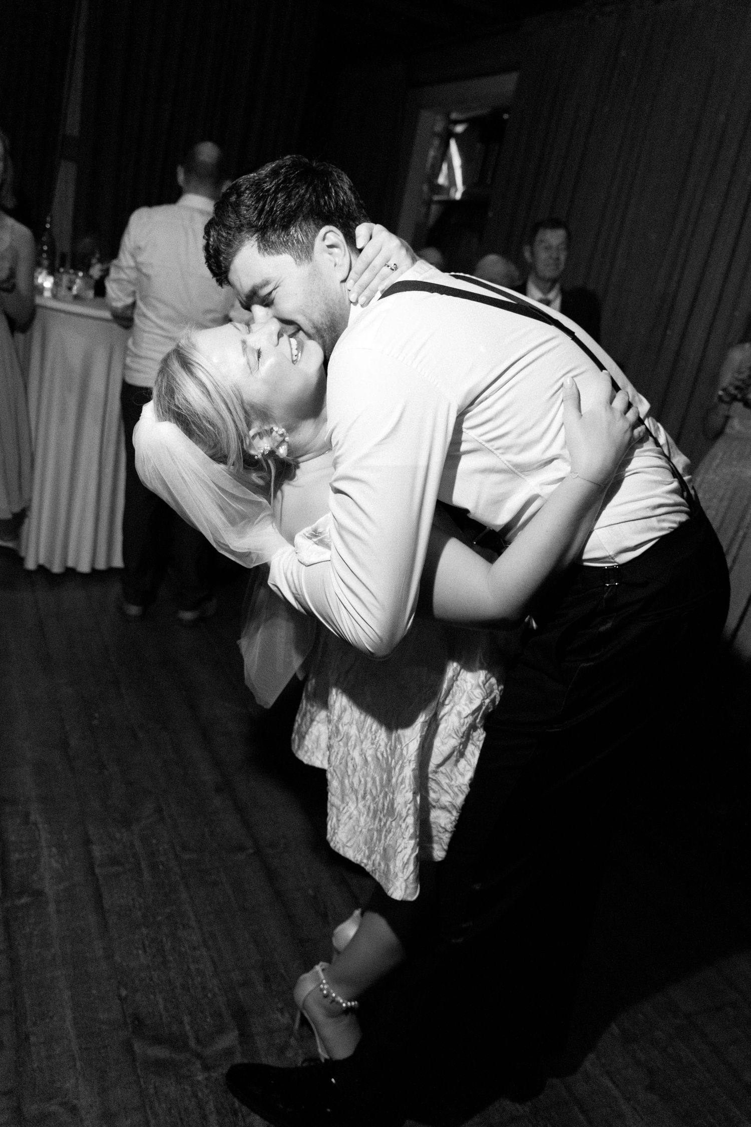 A black and white photo series showing a romantic dance dip sequence at a wedding reception.