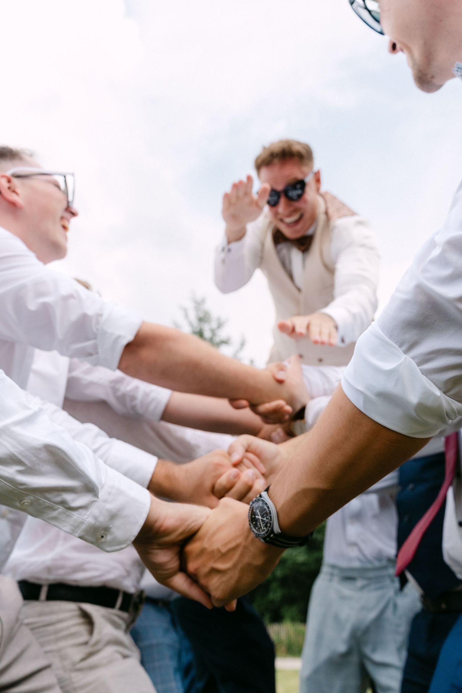 A sequence of four photos showing people in white shirts practicing martial arts self-defense moves outdoors.