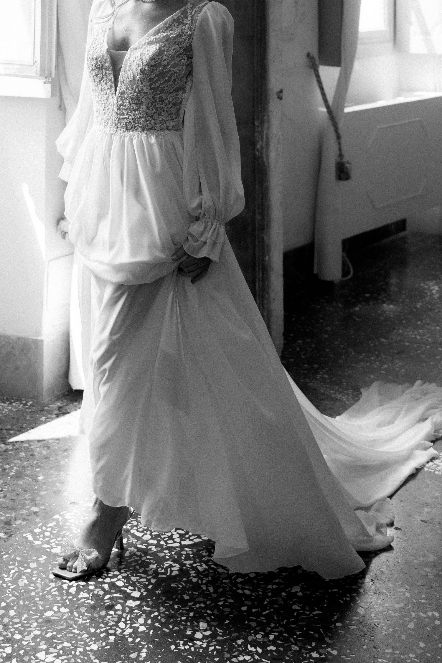 A series of black and white photos showing a flowing white wedding dress with scattered flower petals on the floor. Wedding Verona