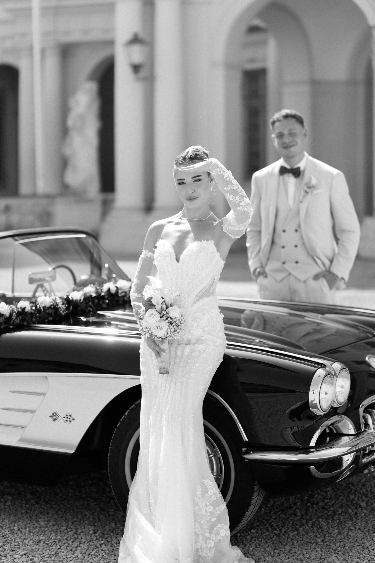Black and white wedding photo series showing a couple posing elegantly next to a luxury car. Schloss Ludwigsburg