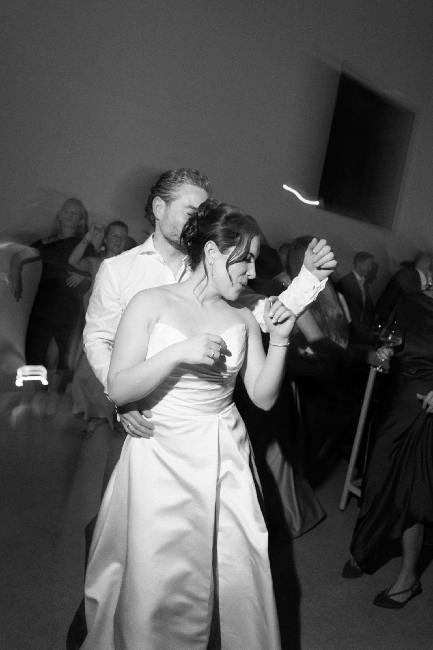 Black and white photo of bride and groom sharing first dance at wedding reception.