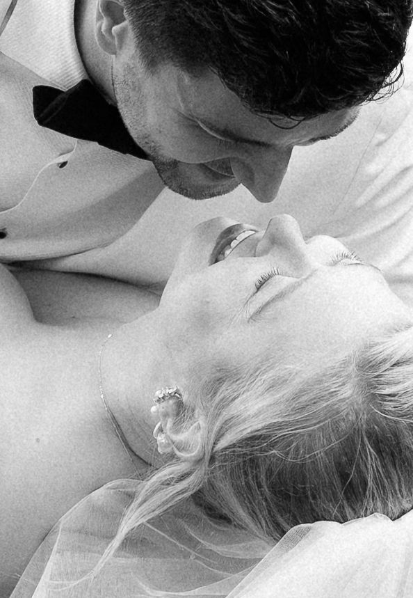 A series of black and white romantic photos showing tender moments between a couple in white clothing.