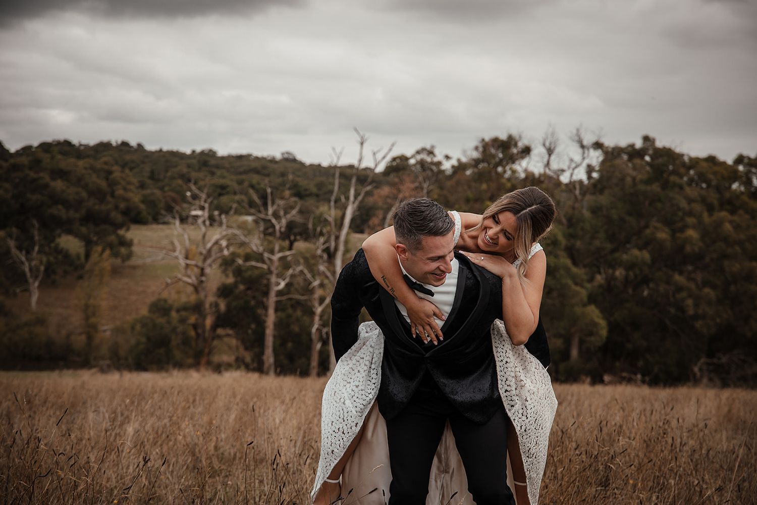 Romantic couple embraces in rustic outdoor setting during wedding photoshoot. Wedding photography