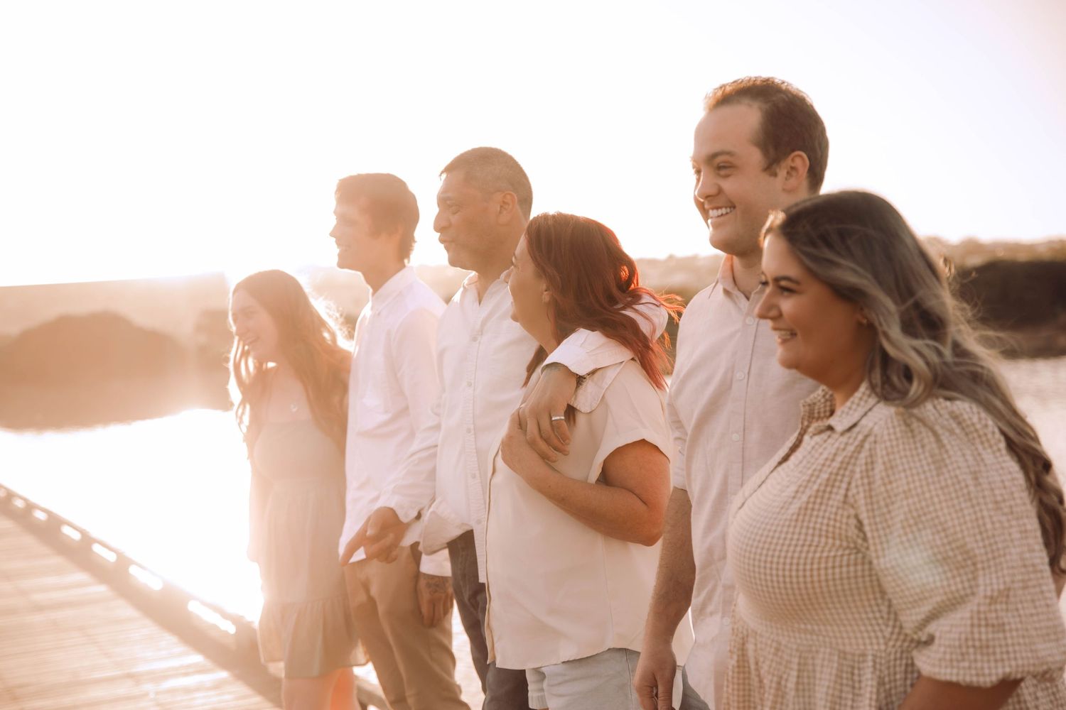 Group enjoying sunset together on waterfront boardwalk. Family Photography
