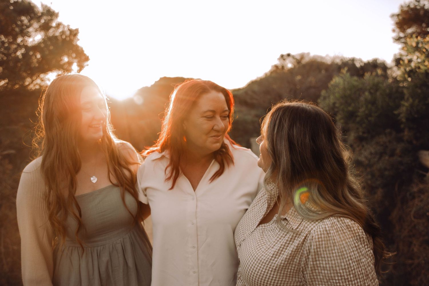 Three friends sharing a joyful moment together during golden hour sunset. Mumma and me sessions