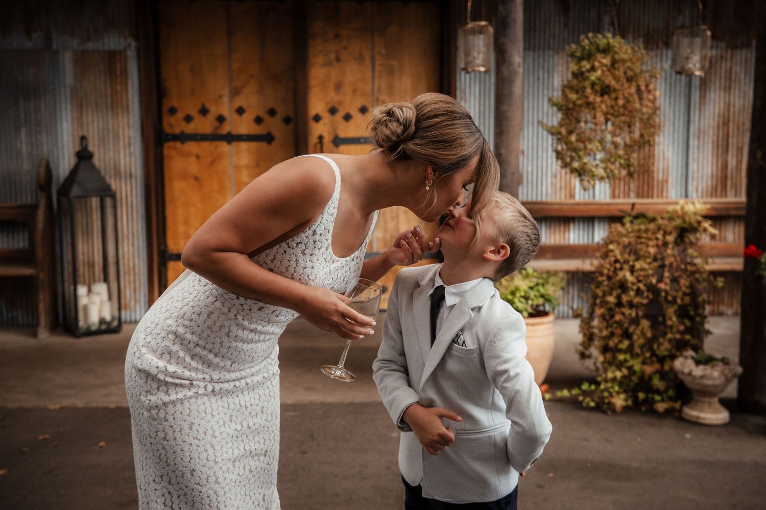 A romantic couple shares an intimate moment in front of a rustic wooden barn setting. Wedding photography