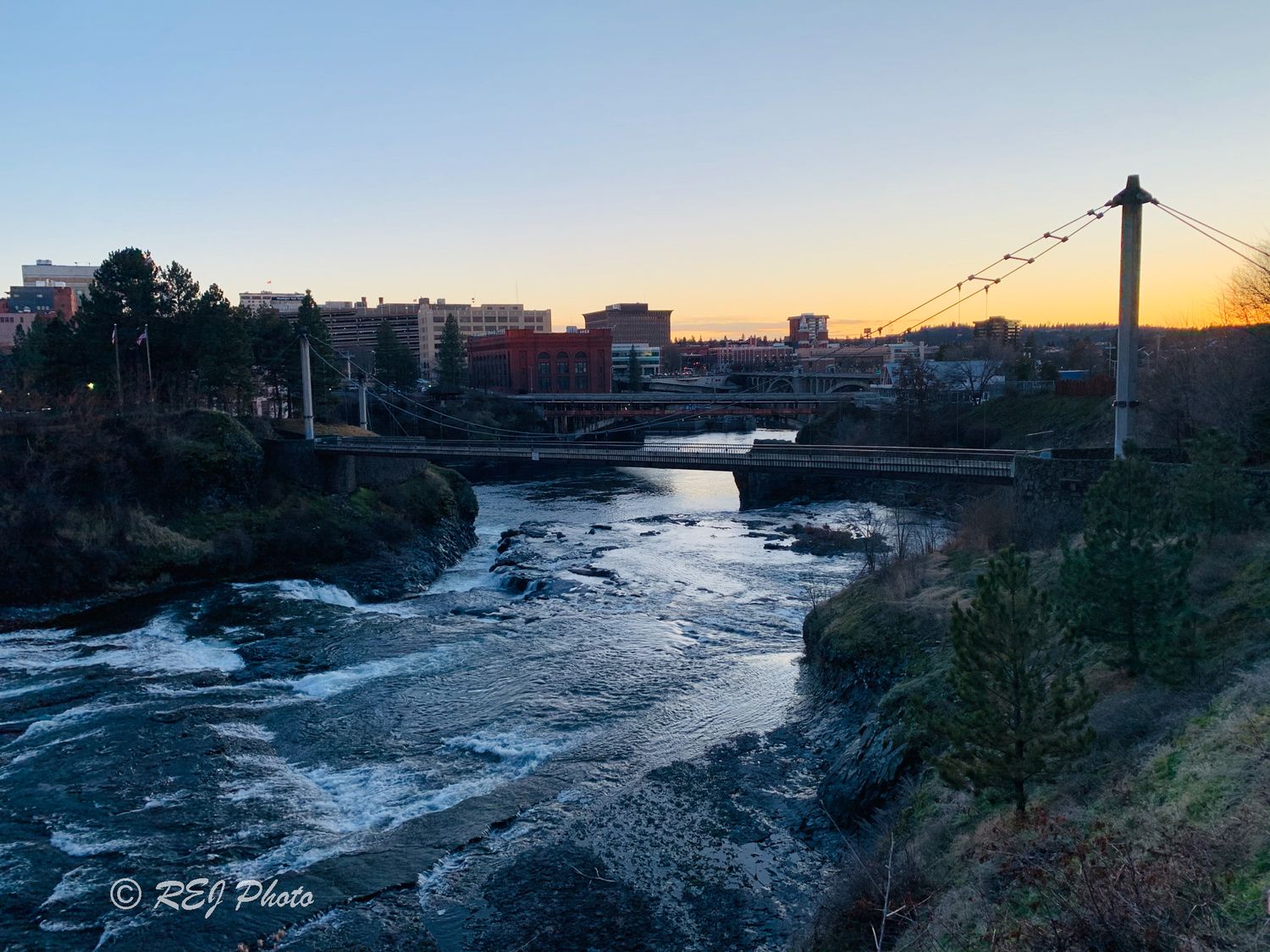 Panoramic view of the Spokane River at sunset with cresting of  buildings of Spokane.