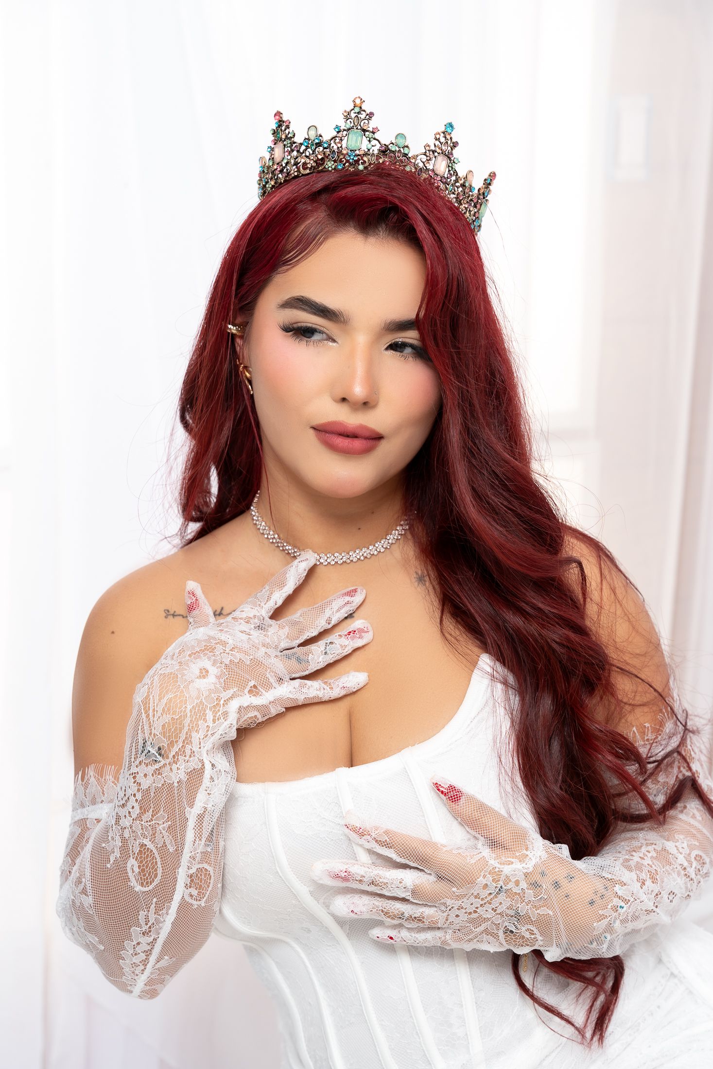 Glamorous portrait session featuring crystal crown and white lace gloves.