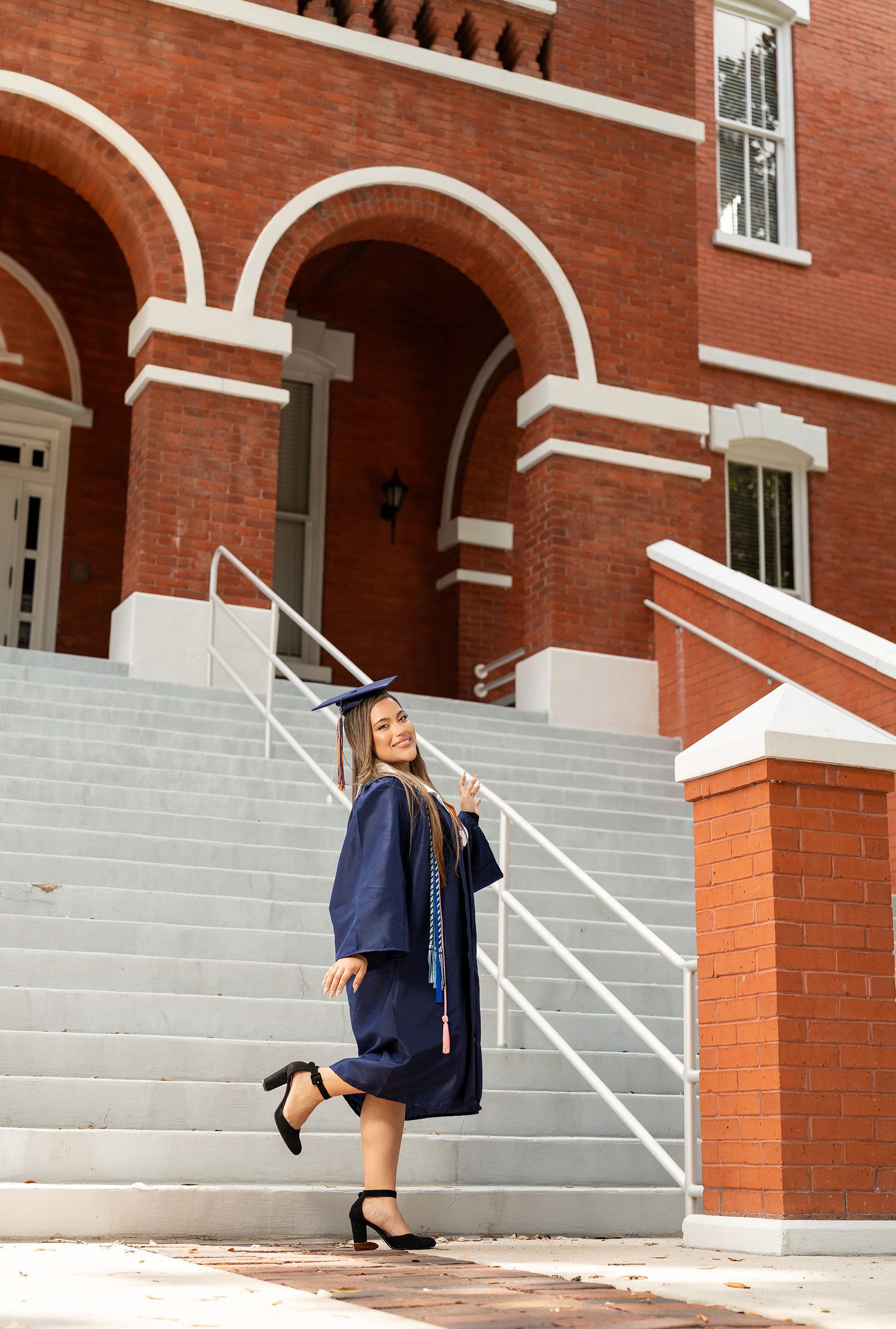A series of four architectural arches with white stone steps and red brick columns on a historic building facade.