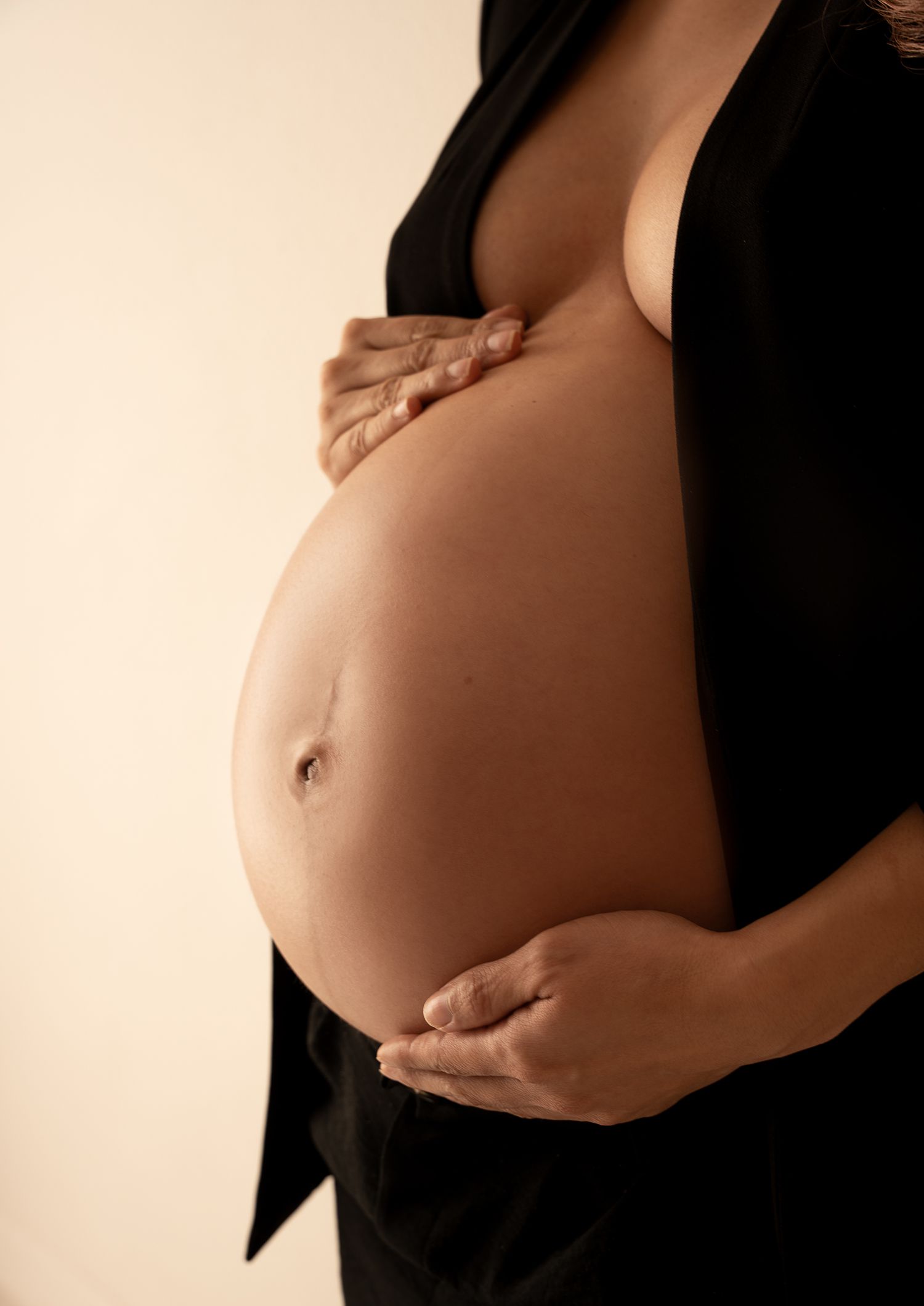 A series of artistic maternity photos showing a pregnant belly against a light background in various poses.