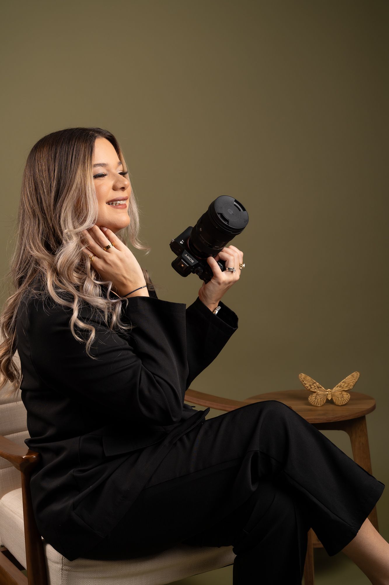 Artistic self-portrait series showing photographer in black dress holding camera in different poses.