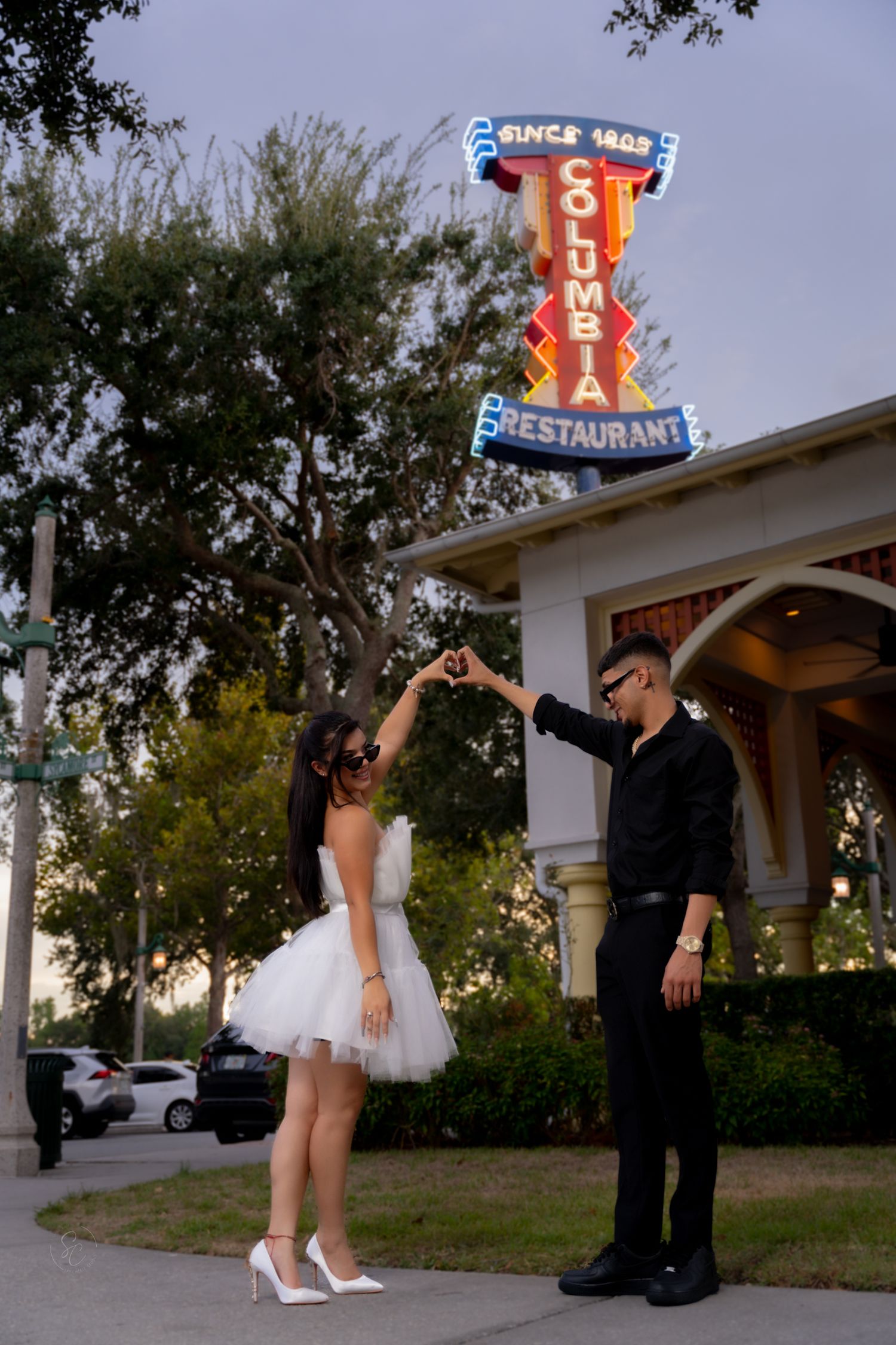 Dance-inspired poses captured outside a classic diner with neon signs.