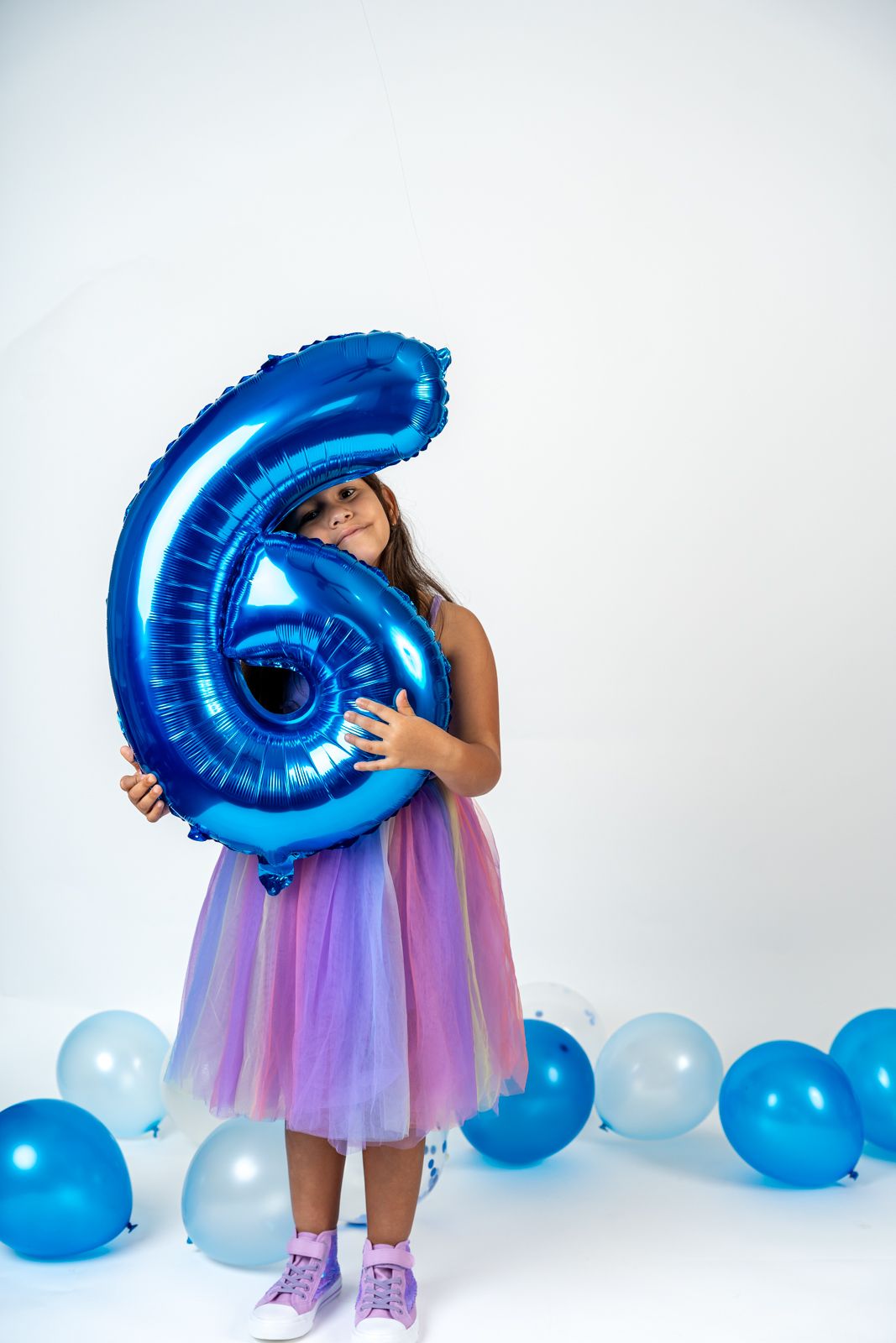 Birthday photoshoot with large blue number 4 balloon and pastel tulle dress.