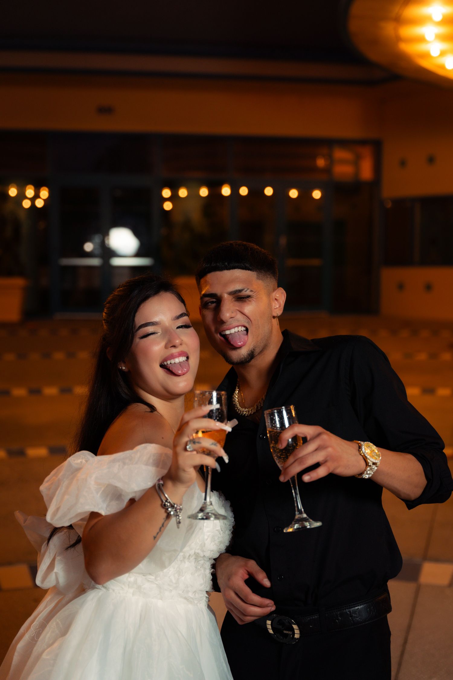 A celebratory toast with champagne glasses during a nighttime celebration.